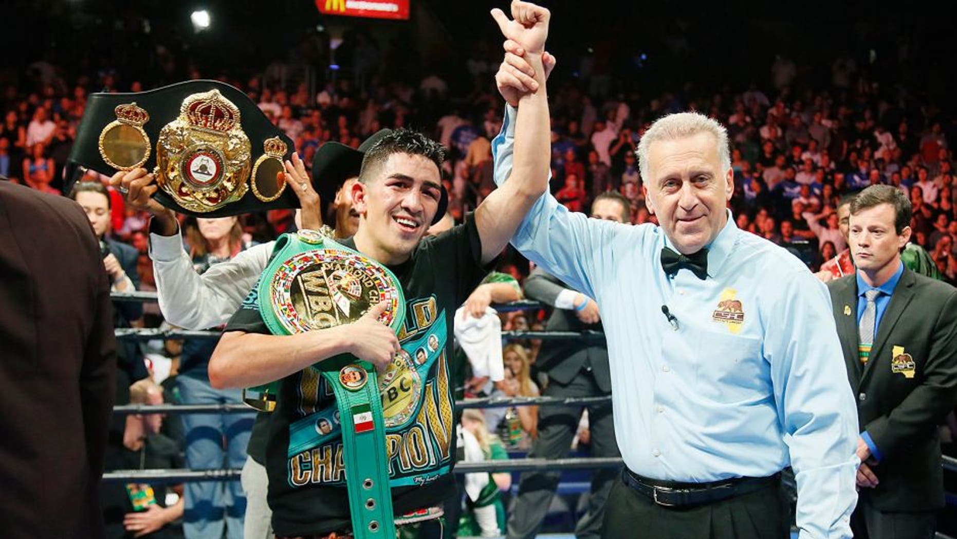 Leo Santa Cruz celebrates after he was announced the winner against Abner Mares in their WBC diamond featherweight and WBA featherweight championship boxing bout, Saturday, Aug. 29, 2015, in Los Angeles. (AP Photo/Danny Moloshok)