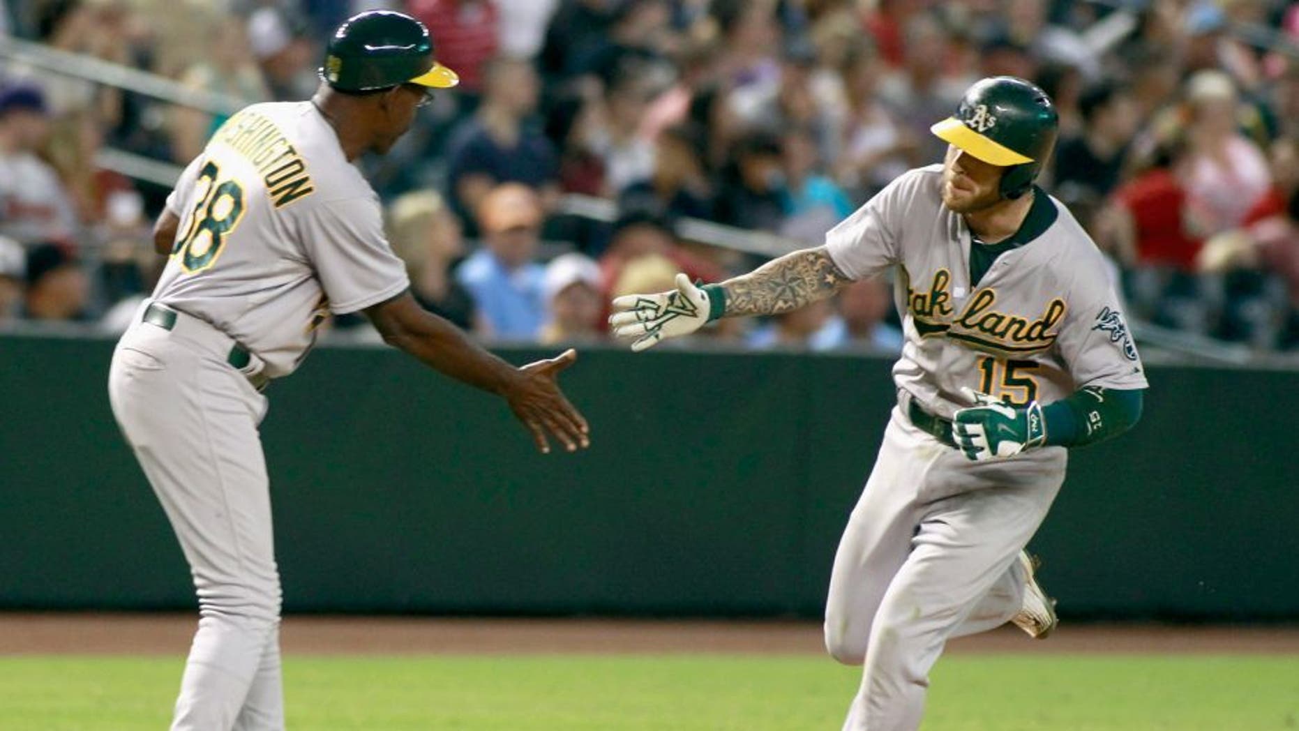 PHOENIX, AZ - AUGUST 28: Brett Lawrie #15 of the Oakland Athletics is congratulated by third base coach Ron Washington #38 after hitting a two-run home run against the Arizona Diamondbacks during the ninth inning of a MLB game at Chase Field on August 28, 2015 in Phoenix, Arizona. (Photo by Ralph Freso/Getty Images)