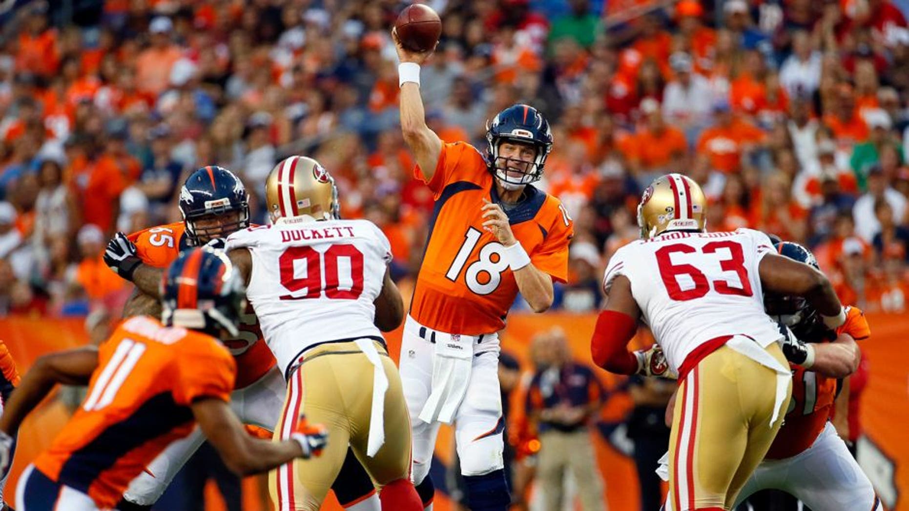 Denver Broncos quarterback Peyton Manning (18) throws as San Francisco 49ers defensive tackle Darnell Dockett (90) and Tony Jerod-Eddie (63) rush during the first half of an NFL preseason football game, Saturday, Aug. 29, 2015, in Denver. (AP Photo/Jack Dempsey)