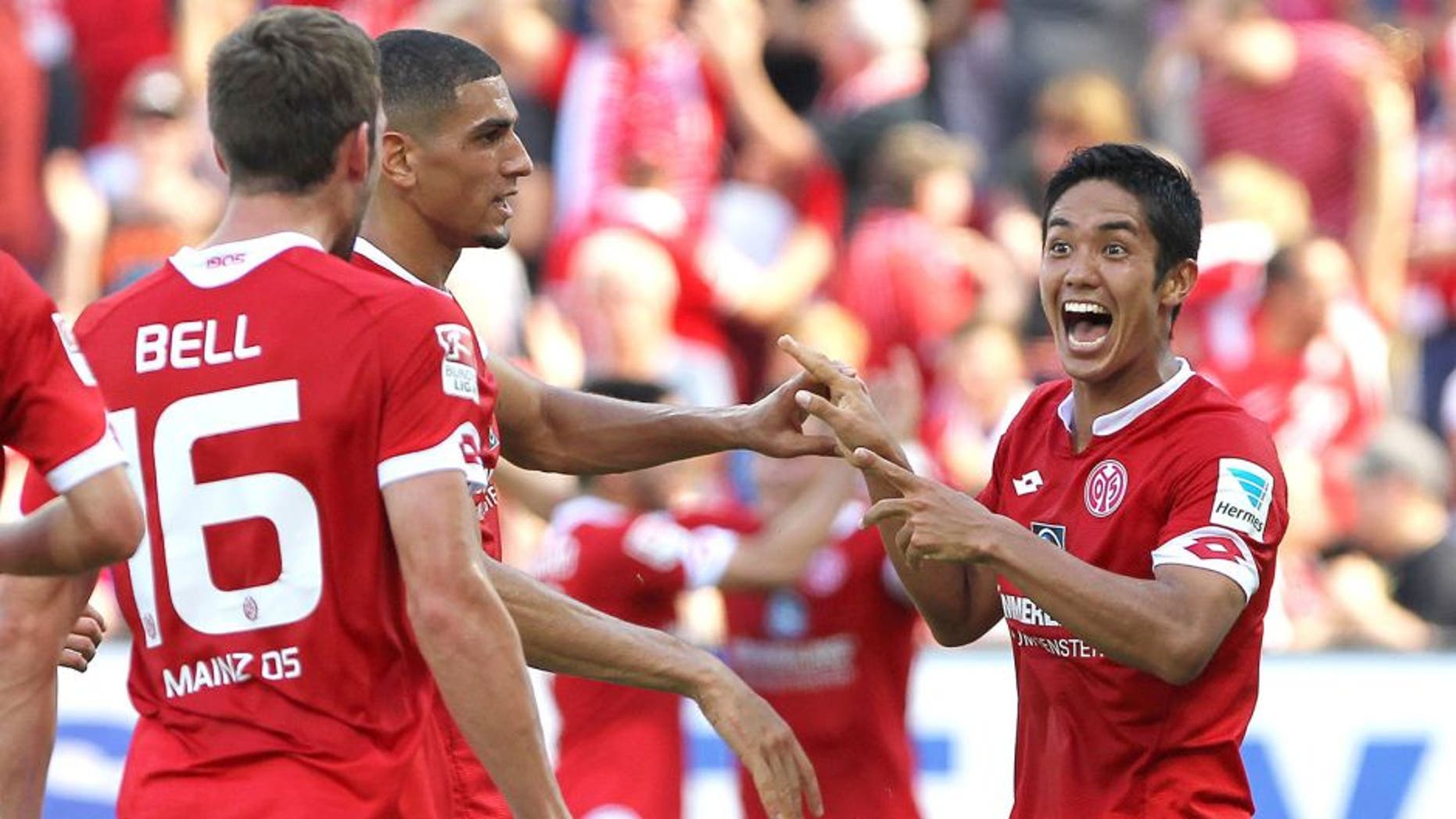 Mainz' Japanese striker Yoshinori Muto (R) celebrates scoring the 2-0 with teammates during the German first division Bundesliga football match 1 FSV Mainz 05 vs Hannover 96 in Mainz, Germany, on August 29, 2015. AFP PHOTO / DANIEL ROLAND RESTRICTIONS: DURING MATCH TIME: DFL RULES TO LIMIT THE ONLINE USAGE TO 15 PICTURES PER MATCH AND FORBID IMAGE SEQUENCES TO SIMULATE VIDEO. == RESTRICTED TO EDITORIAL USE == FOR FURTHER QUERIES PLEASE CONTACT DFL DIRECTLY AT + 49 69 650050. (Photo credit should read DANIEL ROLAND/AFP/Getty Images)