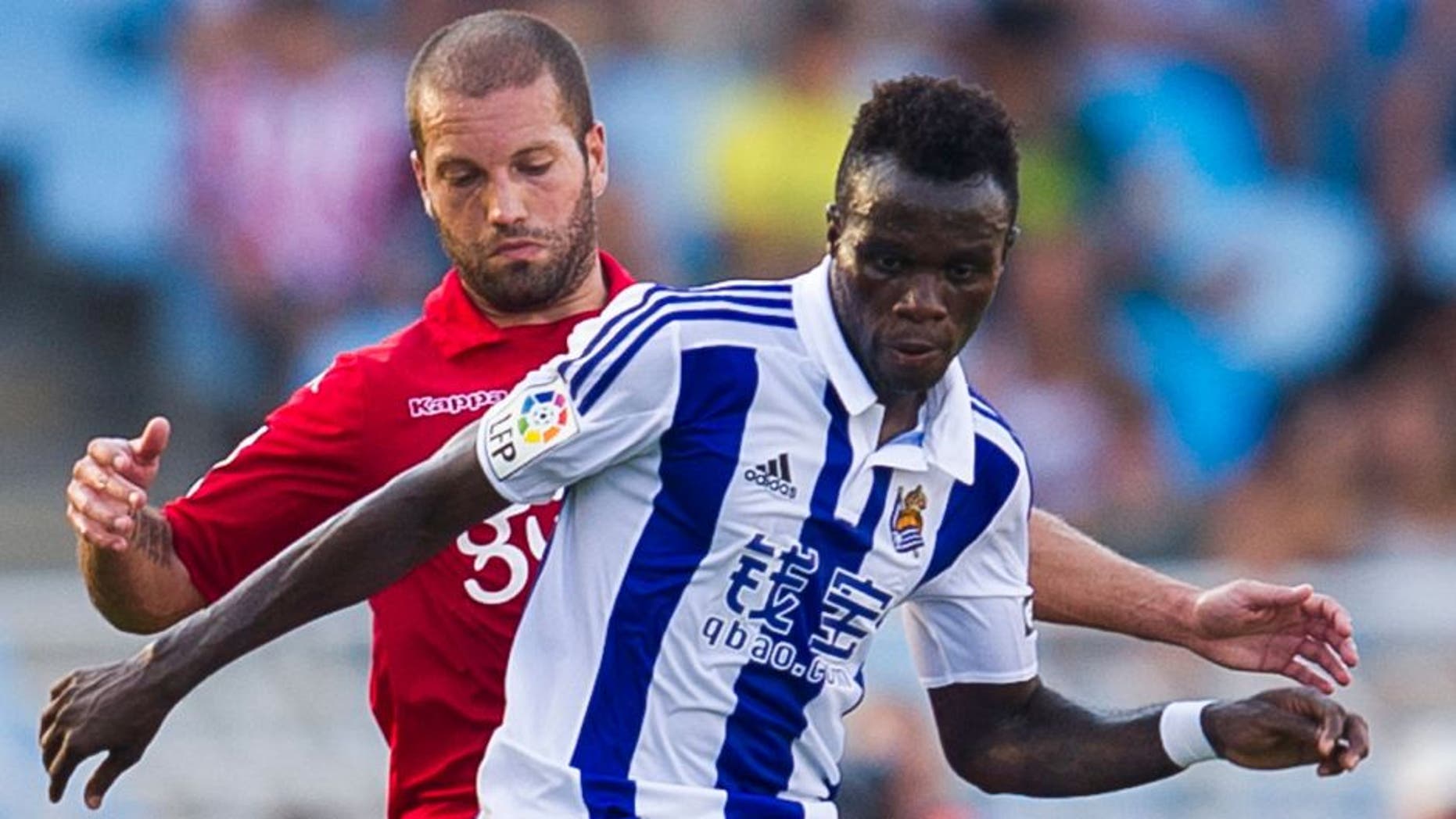 SAN SEBASTIAN, SPAIN - AUGUST 29: Tue Na Bangna Bruma of Real Sociedad de Futbol duels for the ball with Alberto Lora of Sporting Gijon during the La Liga match between Real Sociedad de Futbol and Sporting Gijon at Estadio Anoeta on August 29, 2015 in San Sebastian, Spain. (Photo by Juan Manuel Serrano Arce/Getty Images)