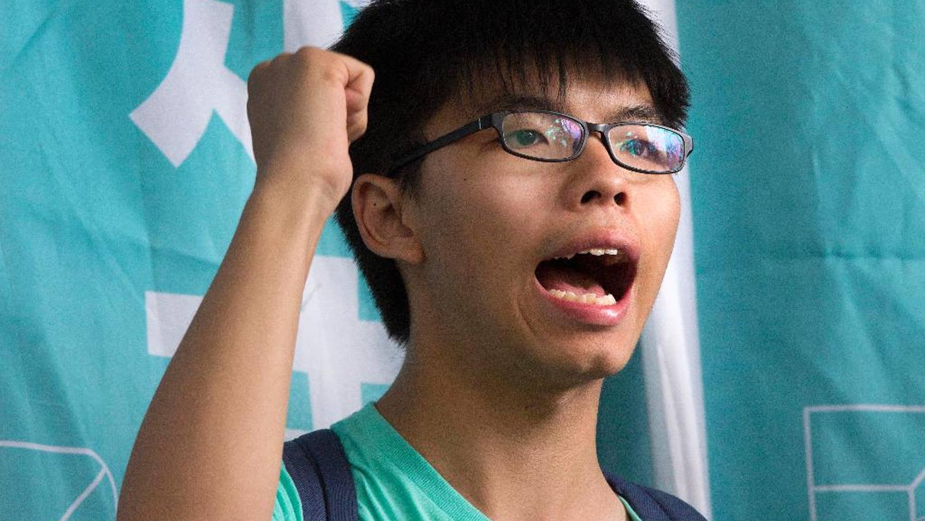 FILE - In this Aug. 15, 2016 file photo, Hong Kong student pro-democracy activist Joshua Wong shouts slogans outside a magistrate's court in Hong Kong. Wong has been detained by Thai officials after arriving to give a talk at a university, his political party said. Demosisto said in a Facebook post that the party was unable to contact Wong after he arrived at Bangkok's main airport late Tuesday, Oct. 4, 2016. The group said it got word early Wednesday, Oct. 5 from a Thai student activist who was expected to meet Wong that he had been detained at Suvarnabhumi Airport after Thai authorities received a request from the Chinese government about his visit. (AP Photo/Vincent Yu, File)
