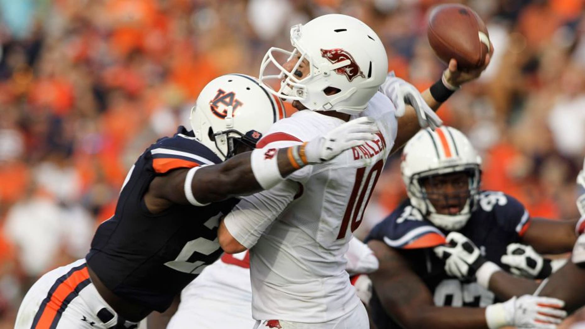 Aug 30, 2014; Auburn, AL, USA; Arkansas Razorbacks quarterback Brandon Allen (10) is hit by Auburn Tigers defensive back Robenson Therezie (27) during the second half at Jordan Hare Stadium. Mandatory Credit: John Reed-USA TODAY Sports