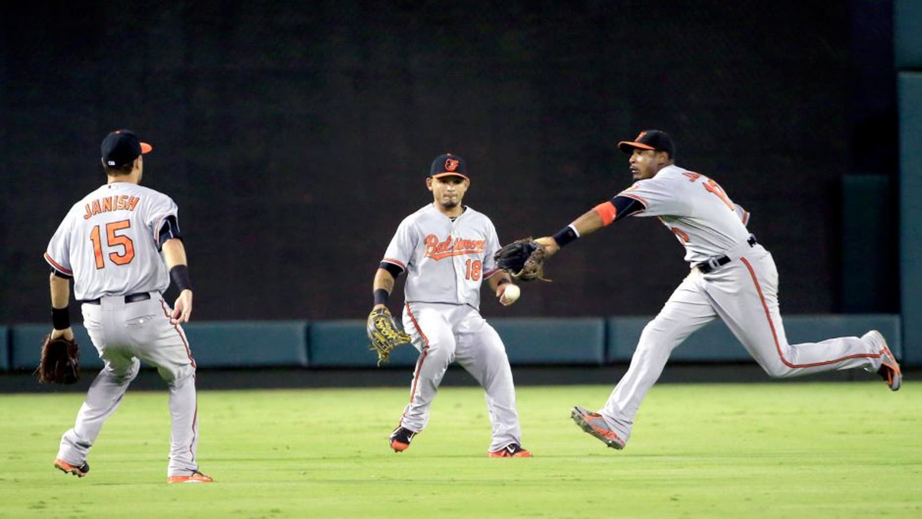 Aug 29, 2015; Arlington, TX, USA; Baltimore Orioles center fielder Adam Jones (10) and left fielder Gerardo Parra (18) and shortstop Paul Janish (15) cannot catch a fly ball during the fourth inning against the Texas Rangers at Globe Life Park in Arlington. Mandatory Credit: Kevin Jairaj-USA TODAY Sports