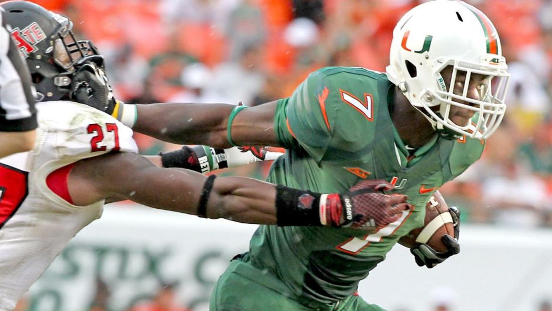 Miami's Gus Edwards pushes off Arkansas State's Money Hunter as he scores a second-quarter touchdown on a 27-yard run at Sun Life Stadium in Miami Gardens, Fla., on Saturday, Sept. 13, 2014. (Charles Trainor Jr./Miami Herald/MCT)