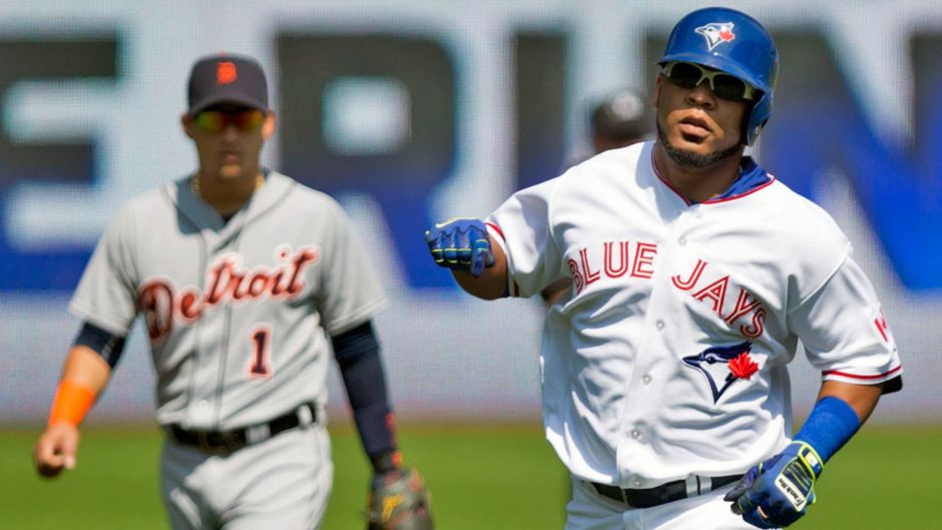 Toronto Blue Jays' Edwin Encarnacion, right, rounds the bases after hitting a solo home run off Detroit Tigers starting pitcher Alfredo Simon as Tigers' shortstop Jose Iglesias, left, looks on during first-inning baseball game action in Toronto, Sunday, Aug. 30, 2015. (Chris Young/The Canadian Press via AP) MANDATORY CREDIT