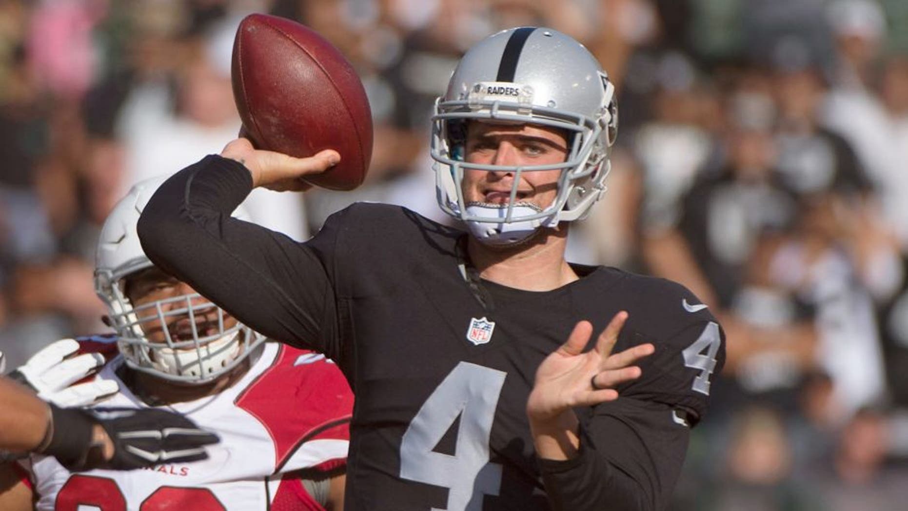 August 30, 2015; Oakland, CA, USA; Oakland Raiders quarterback Derek Carr (4) passes the football against Arizona Cardinals outside linebacker Lorenzo Alexander (97) during the first quarter in a preseason NFL football game at O.co Coliseum. Mandatory Credit: Kyle Terada-USA TODAY Sports