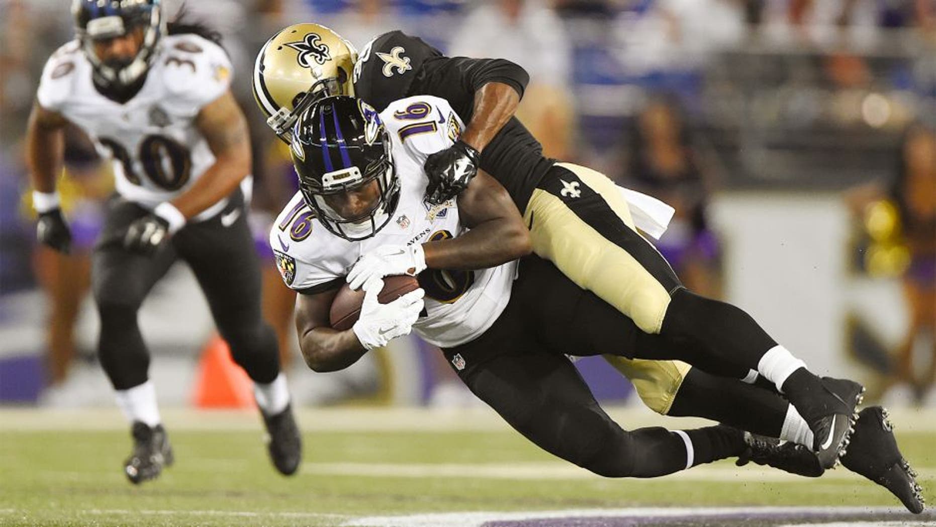 Aug 13, 2015; Baltimore, MD, USA; New Orleans Saints cornerback Damian Swann (38) tackles Baltimore Ravens wide receiver DeAndre Carter (16) during the fourth quarter in a preseason NFL football game at M&T Bank Stadium. Baltimore Ravens defeated New Orleans Saints 30-27. Mandatory Credit: Tommy Gilligan-USA TODAY Sports