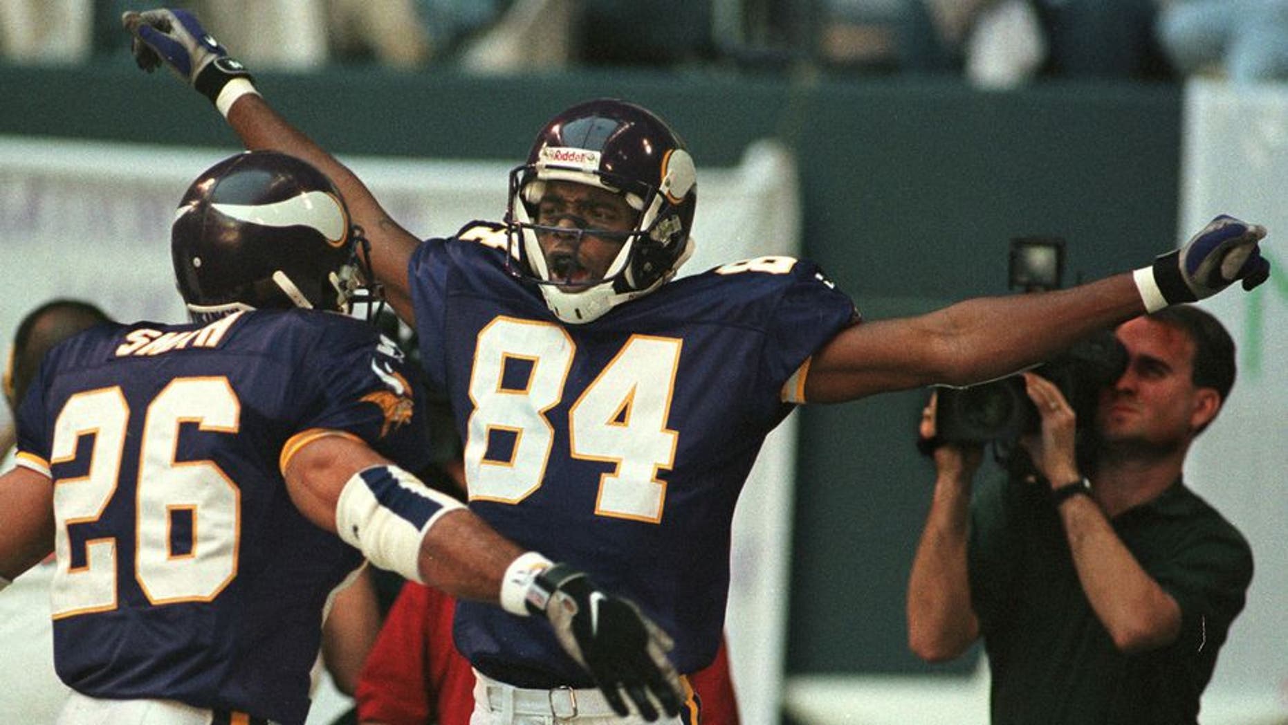 IRVING, : Minnesota Vikings receiver Randy Moss (C) celebrates his 51 yard touchdown reception on the fourth play of the game versus the Dallas Cowboys at Texas Stadium in Irving, TX, 26 November. At left is teammate Robert Smith. AFP PHOTO/PAUL BUCK (Photo credit should read PAUL BUCK/AFP/Getty Images)