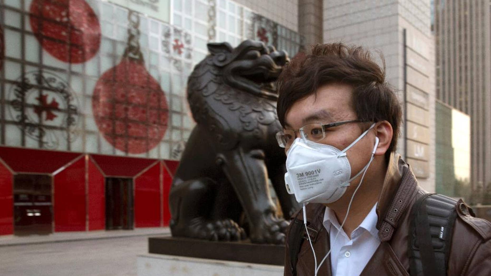 A man wears a mask on the streets of Beijing Friday, March 20, 2015. A U.S. envoy for climate change said Friday that China and the U.S. are working more closely than ever ahead of a conference this year in Paris that raises hopes for a global plan to cut greenhouse emissions. (AP Photo/Ng Han Guan)