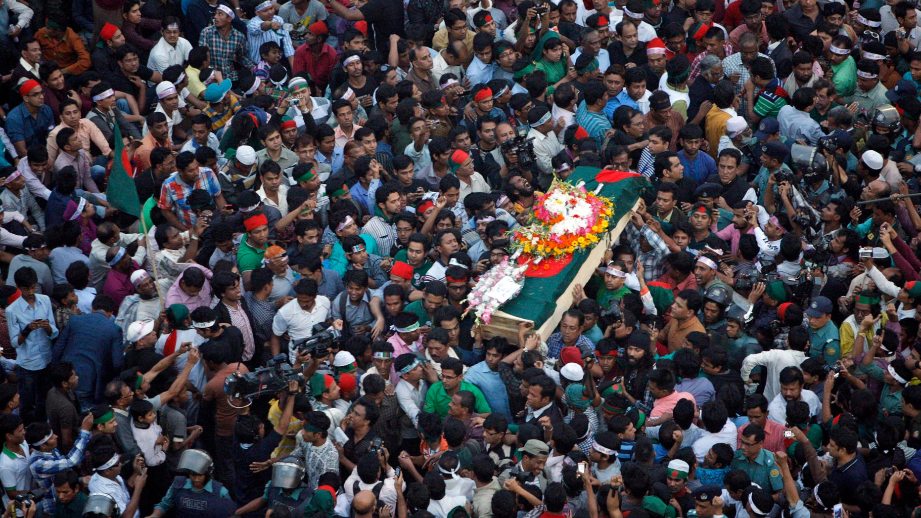 FILE - In this Feb. 16, 2013 file photo, Bangladeshi mourners carry the coffin containing the body of blogger Rajib Haider for funeral in Dhaka, Bangladesh. Haider had been critical of the Islamic group Jamaat-e-Islami, whose leader Abdul Quader Mollah was recently given a life sentence for his role in the killing of 381 civilians during the nation’s 1971 war for independence from Pakistan. On Sunday, Feb. 17, 2013, Bangladesh parliament has amended the country’s war crimes law that will allow the prosecution to appeal the life imprisonment of an opposition leader which it says has been lenient. (AP Photo/Pavel Rahman, File)