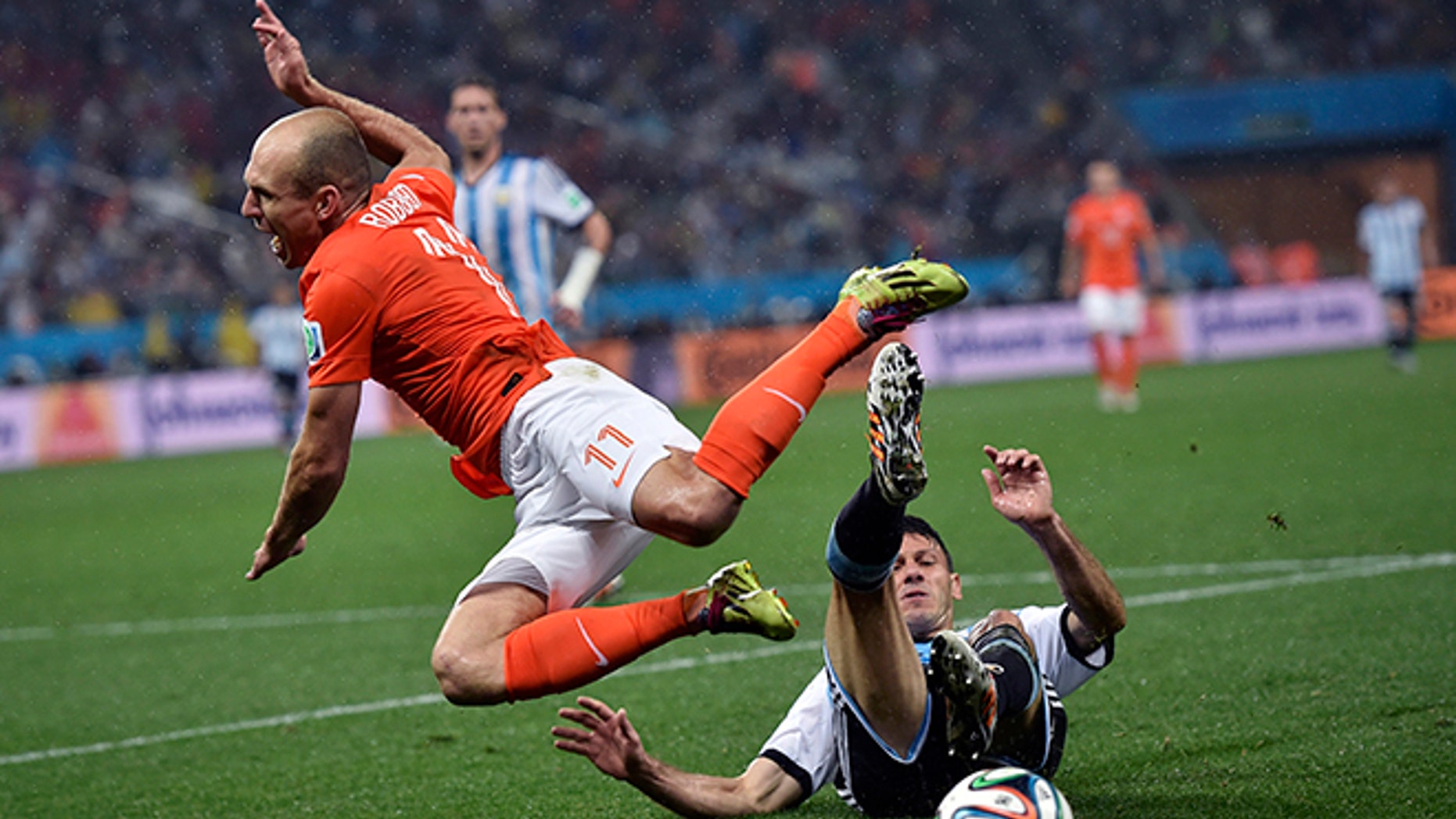 Netherlands' Arjen Robben goes down under a challenge from Argentina's Martin Demichelis during the World Cup semifinal soccer match between the Netherlands and Argentina at the Itaquerao Stadium in Sao Paulo Brazil, Wednesday, July 9, 2014. (AP Photo/Martin Meissner)