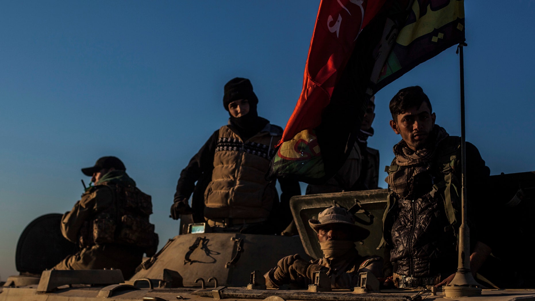 Iraqi Army soldiers are seen atop an armored vehicle while waiting to go to the frontline at the outskirts of Mosul in Al Intisa district, Mosul, Iraq, Tuesday, Dec. 6, 2016.