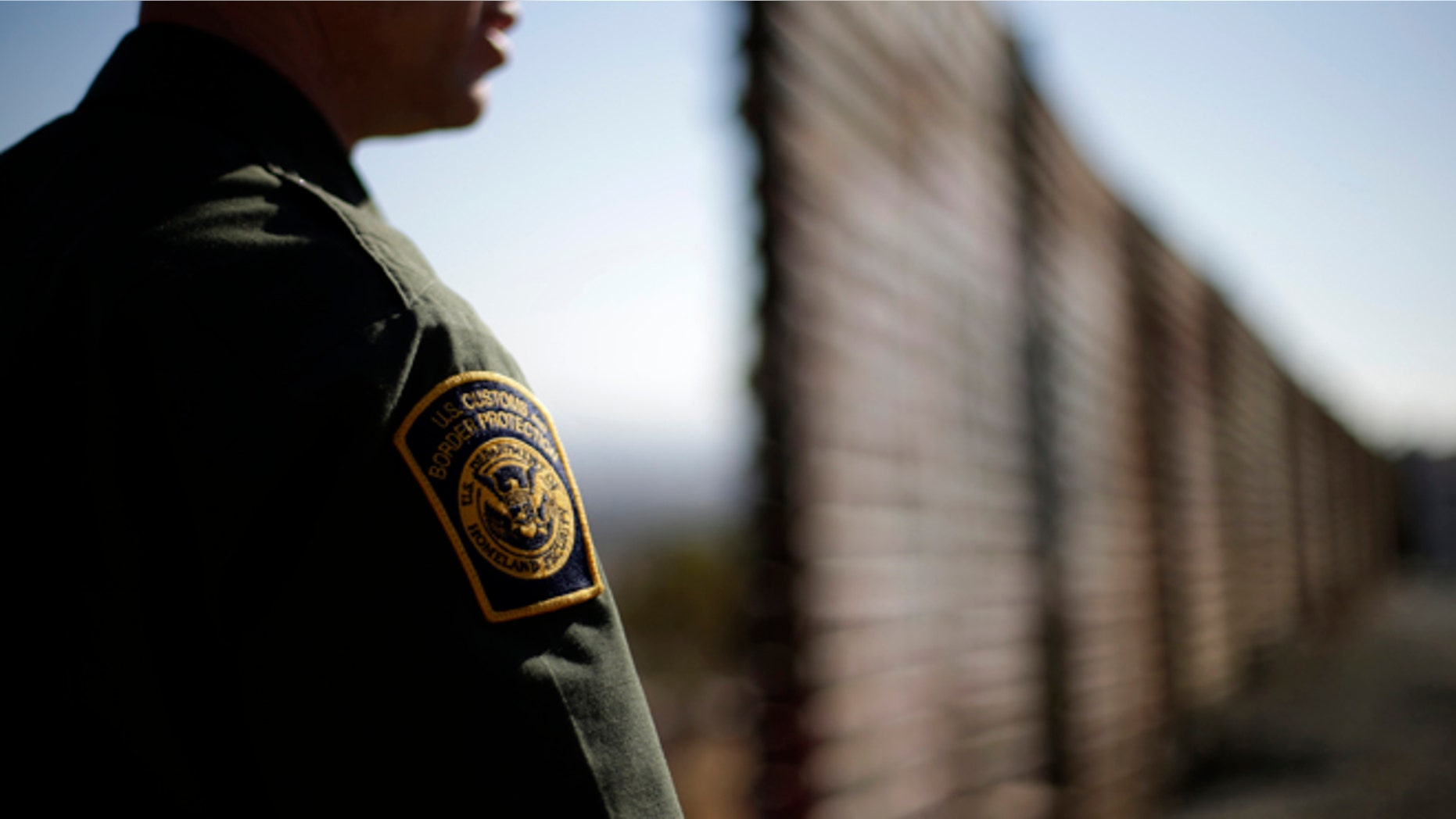 In this June 13, 2013 picture, U.S. Border Patrol agent Jerry Conlin looks to the north near where the border wall ends as is separates Tijuana, Mexico, left, and San Diego, right. Illegal immigration into the United States would decrease by only 25 percent under a far-reaching Senate immigration bill, according to an analysis by the Congressional Budget Office that also finds the measure reduces federal deficits by billions. (AP Photo/Gregory Bull)