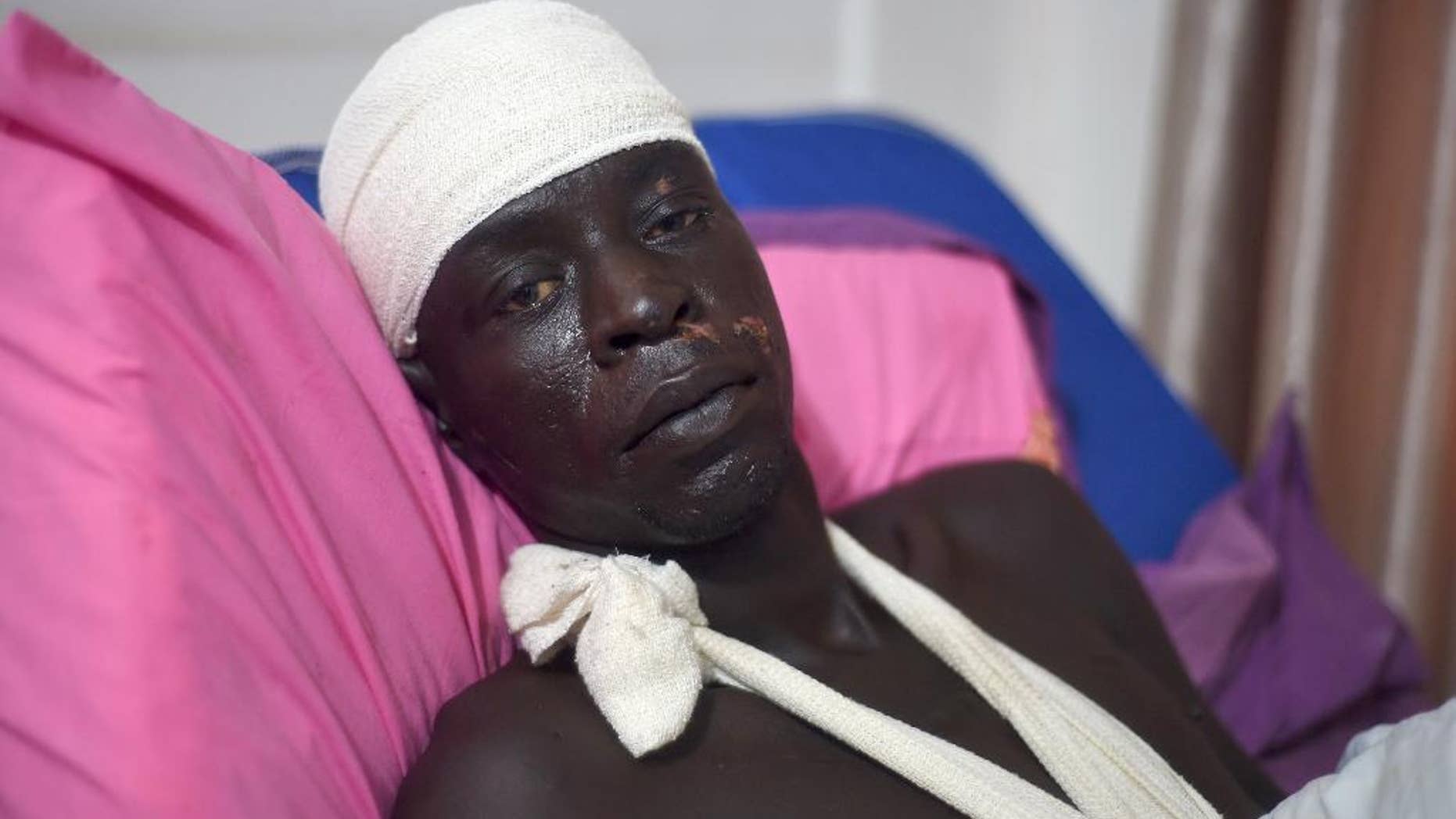 Wuor Arop, one of two survivors of the cargo plane crash which killed at least 37 people Wednesday, lies in a hospital bed in the South Sudan capital Juba on Saturday, Nov. 7, 2015. Arop, who cradled the other survivor, a 13-month old baby who suffered a broken leg and a cut forehead, and is recovering with bones broken in six places and a head injury. Arop said the plane, which was not authorized to transport passengers, carried up to 40 people on board at the time of the crash. (AP Photo/Jason Patinkin)