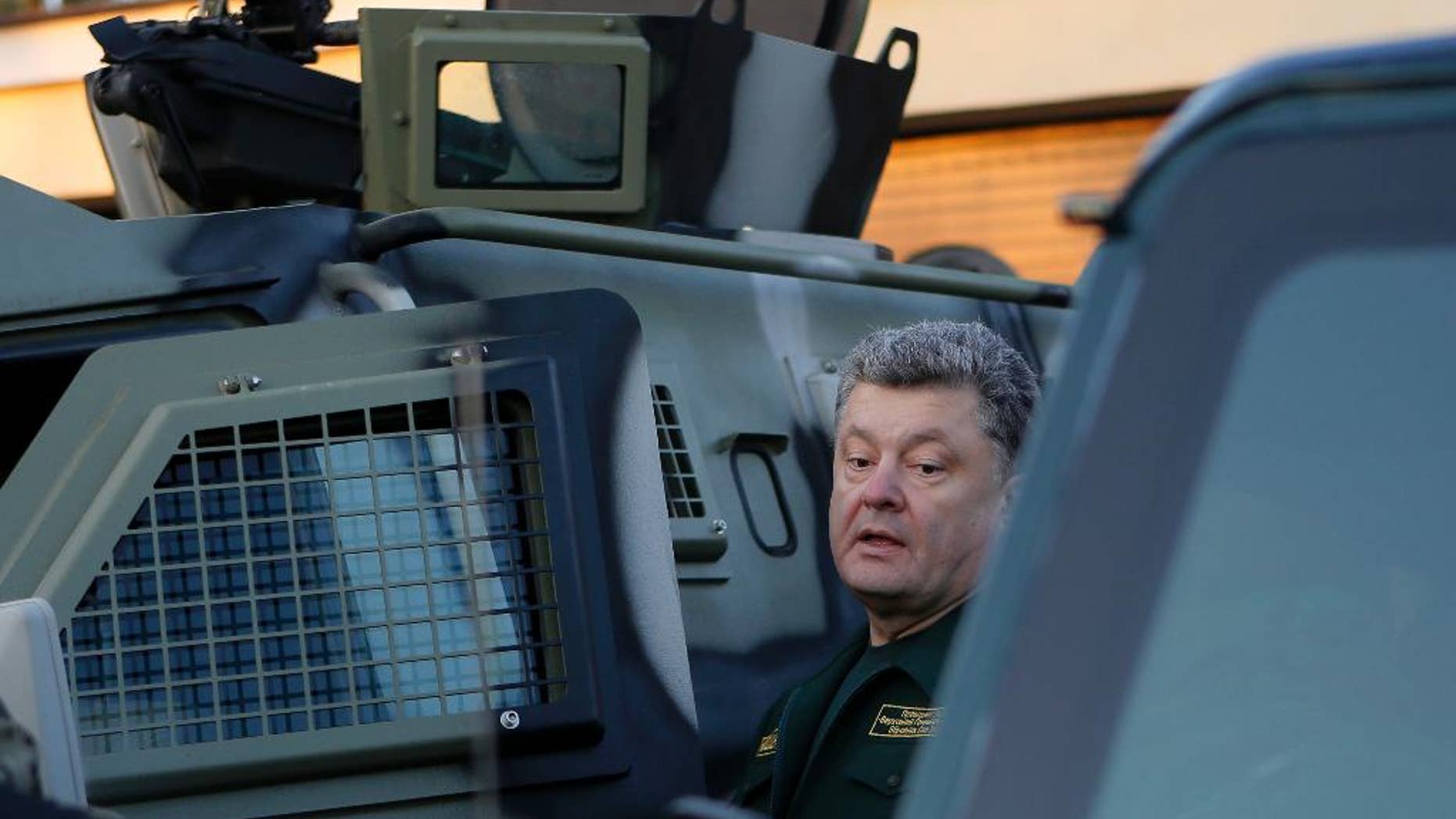 Ukrainian President Petro Poroshenko inspects military armored personnel carriers during his visit in a State Border Guard Service in Kiev, Ukraine, Tuesday, Oct. 7, 2014. (AP Photo/Sergei Chuzavkov)