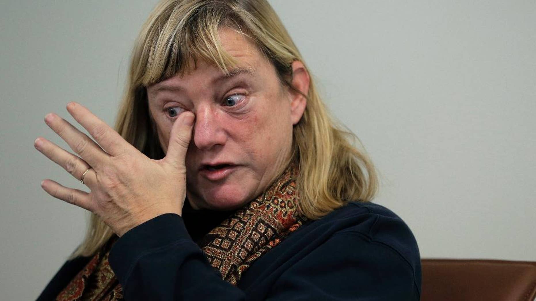 FILE - In this Tuesday, Jan. 5, 2016 file photo Katie Wales Lovkay, of Granby, Conn., who attended St. George's School from 1977-1980, is tearful while facing reporters during a news conference in Boston. Former students of the prestigious boarding school in Middletown, R.I., have called for an independent investigation into sexual abuse that they say spanned three decades and involved at least seven former staff members. Nearly a year after receiving a complaint that a former boarding school psychologist did not do enough to address sexual abuse reports, Rhode Island licensing officials have not resolved it. Lovkay claims she was sexually assaulted by the school's now deceased athletic trainer. (AP Photo/Steven Senne, File)