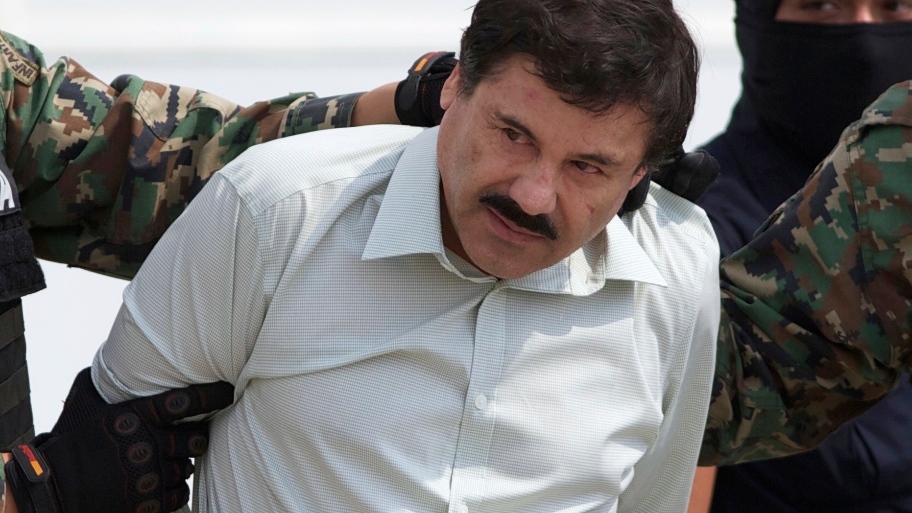 En fotografía del 22 de febrero de 2014 se ve al líderl cártel de Sinaloa Joaquín "El Chapo" Guzmán al ser llevado al helicóptero que lo trasladó a prisión tras ser detenido en la ciudad portuaria de Mazatlán. El procurador de justicia de México Jesús Murillo informó que el gobierno de México no extraditará a Guzmán. (AP Photo/Eduardo Verdugo, File)