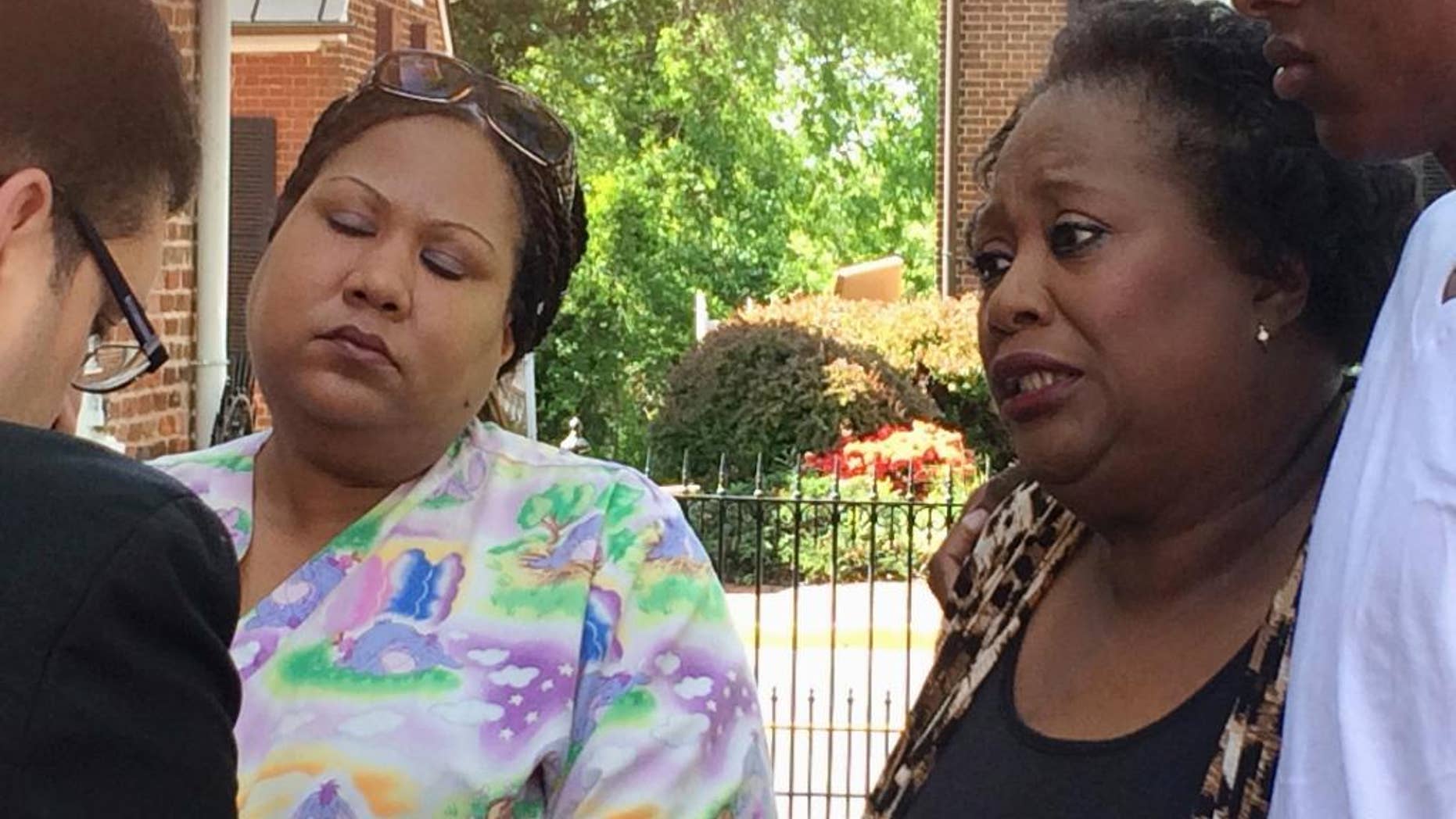 Katherine Thompson, left, daughter of Jammie Lane, and Youdella Allen, Lane's wife in 2009, talk with authorities after a news conference in Leesburg, Va., Tuesday, May 2, 2017, in which authorities announce that an alleged serial killer, Elias Abuelazam, confessed to the stabbing death of Lane eight years ago. (AP Photo/Matthew Barakat)