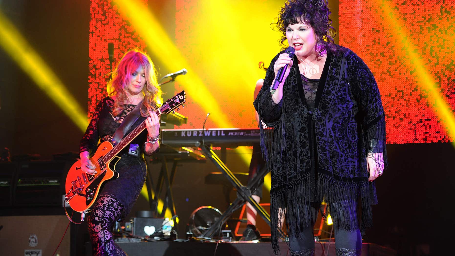 FILE - This June 17, 2013 file photo shows Nancy Wilson, left, and Ann Wilson of Heart performing on opening night of the Heartbreaker Tour at the Cruzan Amphitheater in West Palm Beach, Fla.