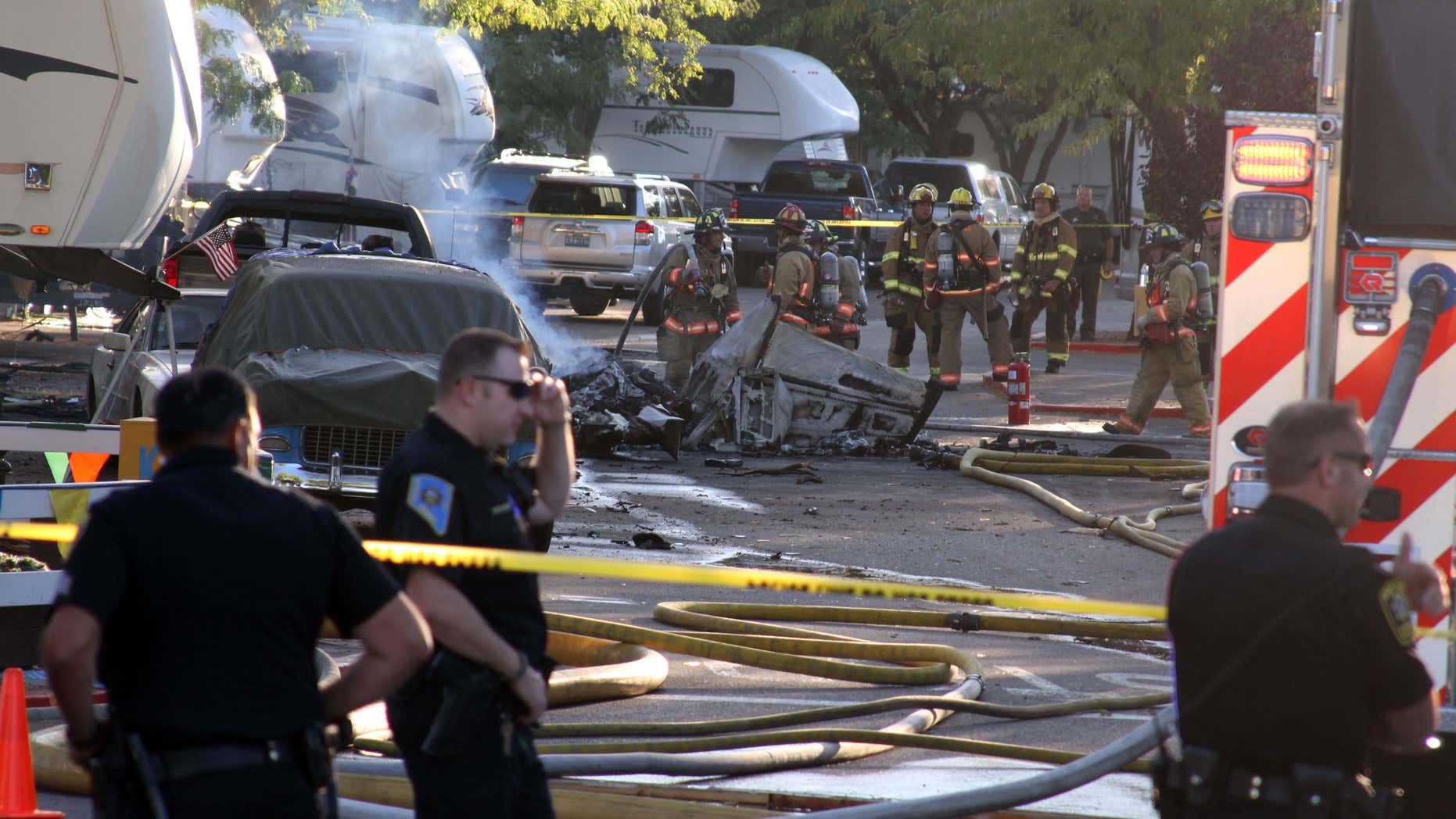 Police and firefighters work at the site of a small plane crash at an RV park Tuesday, Aug. 30, 2016, in Sparks, Nev.