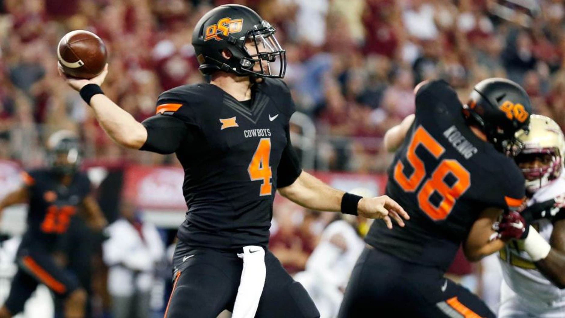 Aug 30, 2014; Arlington, TX, USA; Oklahoma State Cowboys quarterback J.W. Walsh (4) throws against the Florida State Seminoles during the first quarter at AT&T Stadium. Mandatory Credit: Matthew Emmons-USA TODAY Sports