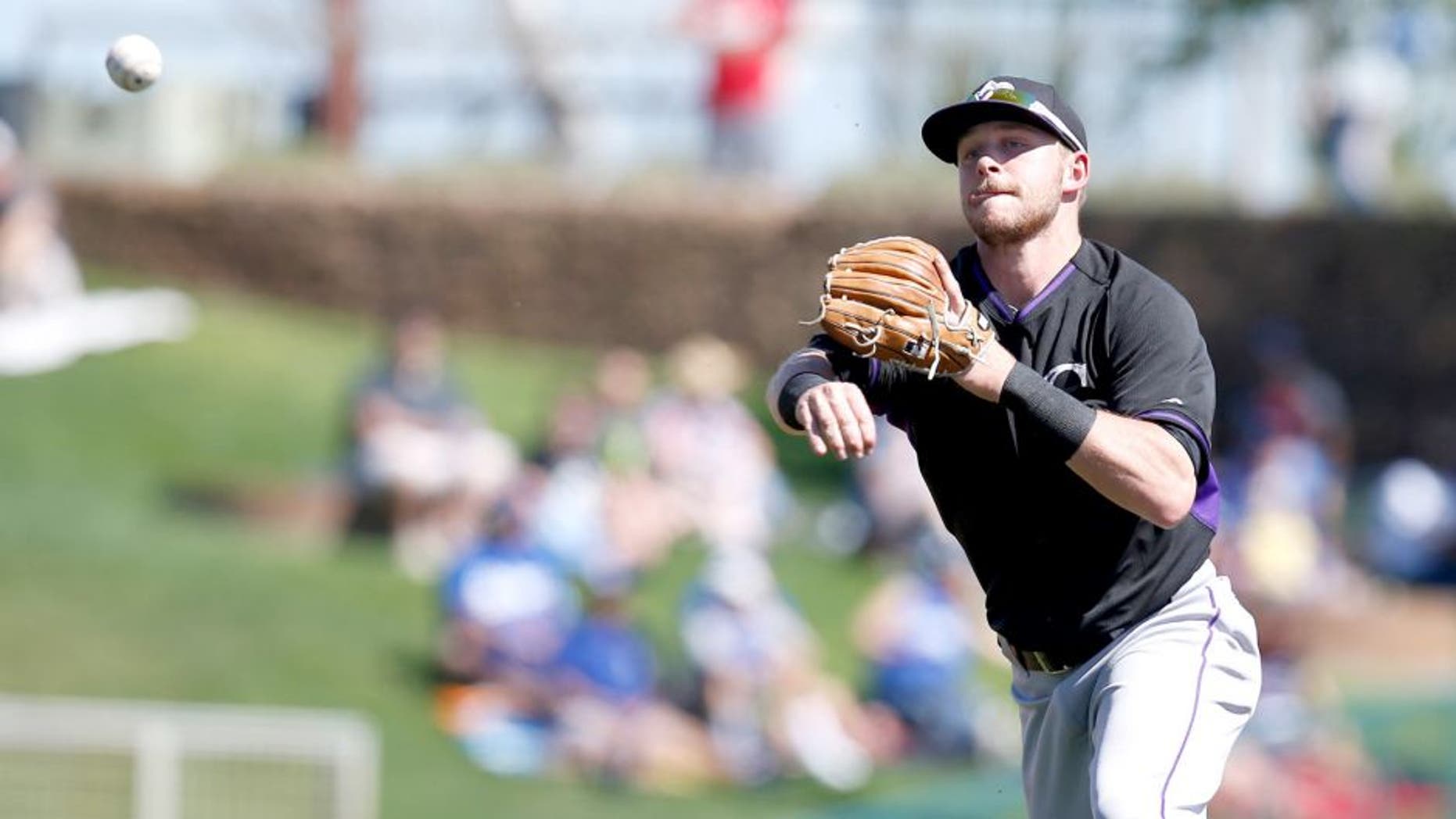 Mar 10, 2015; Phoenix, AZ, USA; Colorado Rockies shortstop Trevor Story (77) makes the off balance throw for the out against the Los Angeles Dodgers in the second inning during a spring training game at Camelback Ranch. Mandatory Credit: Rick Scuteri-USA TODAY Sports