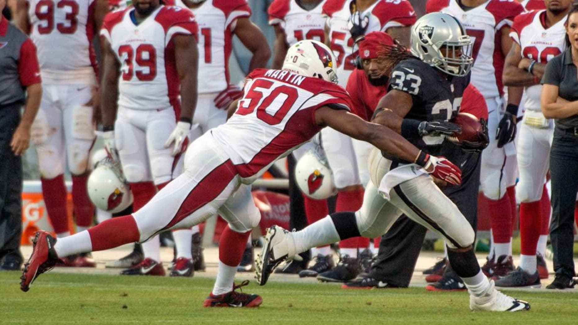 August 30, 2015; Oakland, CA, USA; Oakland Raiders running back Trent Richardson (33) runs with the ball against Arizona Cardinals linebacker Gabe Martin (50) during the third quarter in a preseason NFL football game at O.co Coliseum. The Cardinals defeated the Raiders 30-23. Mandatory Credit: Kyle Terada-USA TODAY Sports