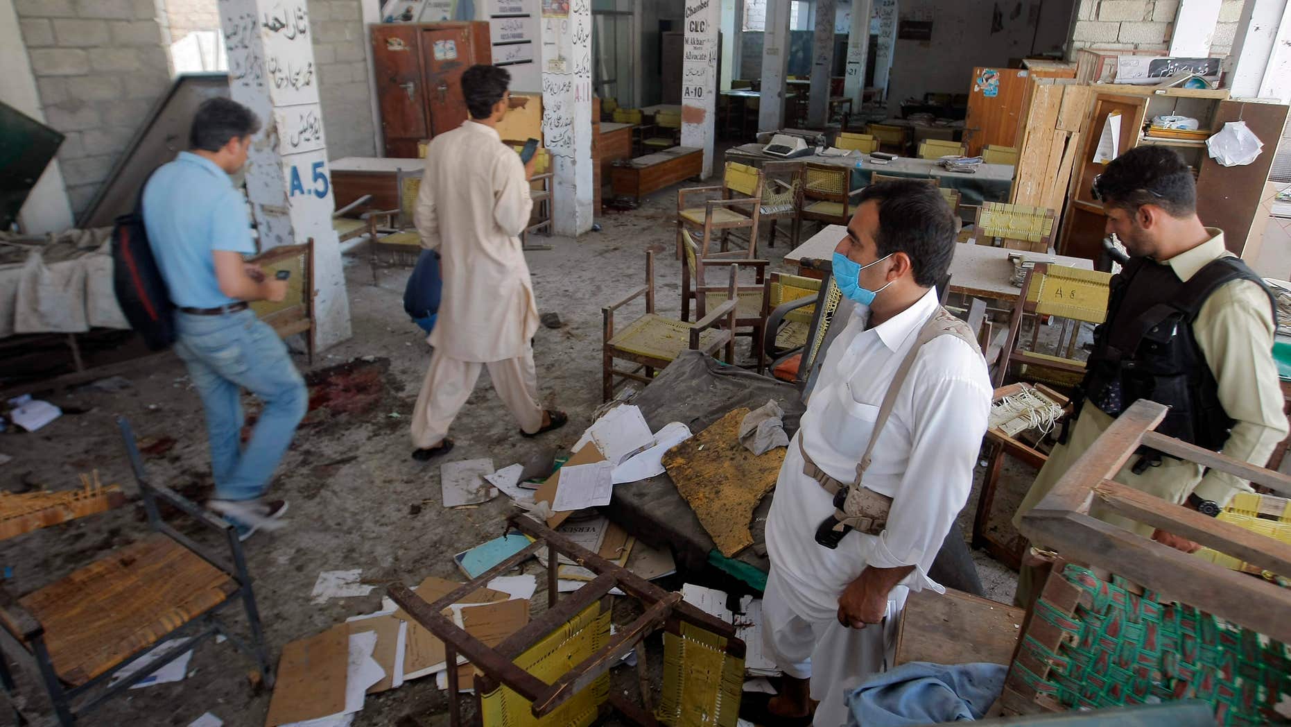 Sept. 2, 2016: Pakistani officials examine a site of bombing in Mardan, Pakistan.