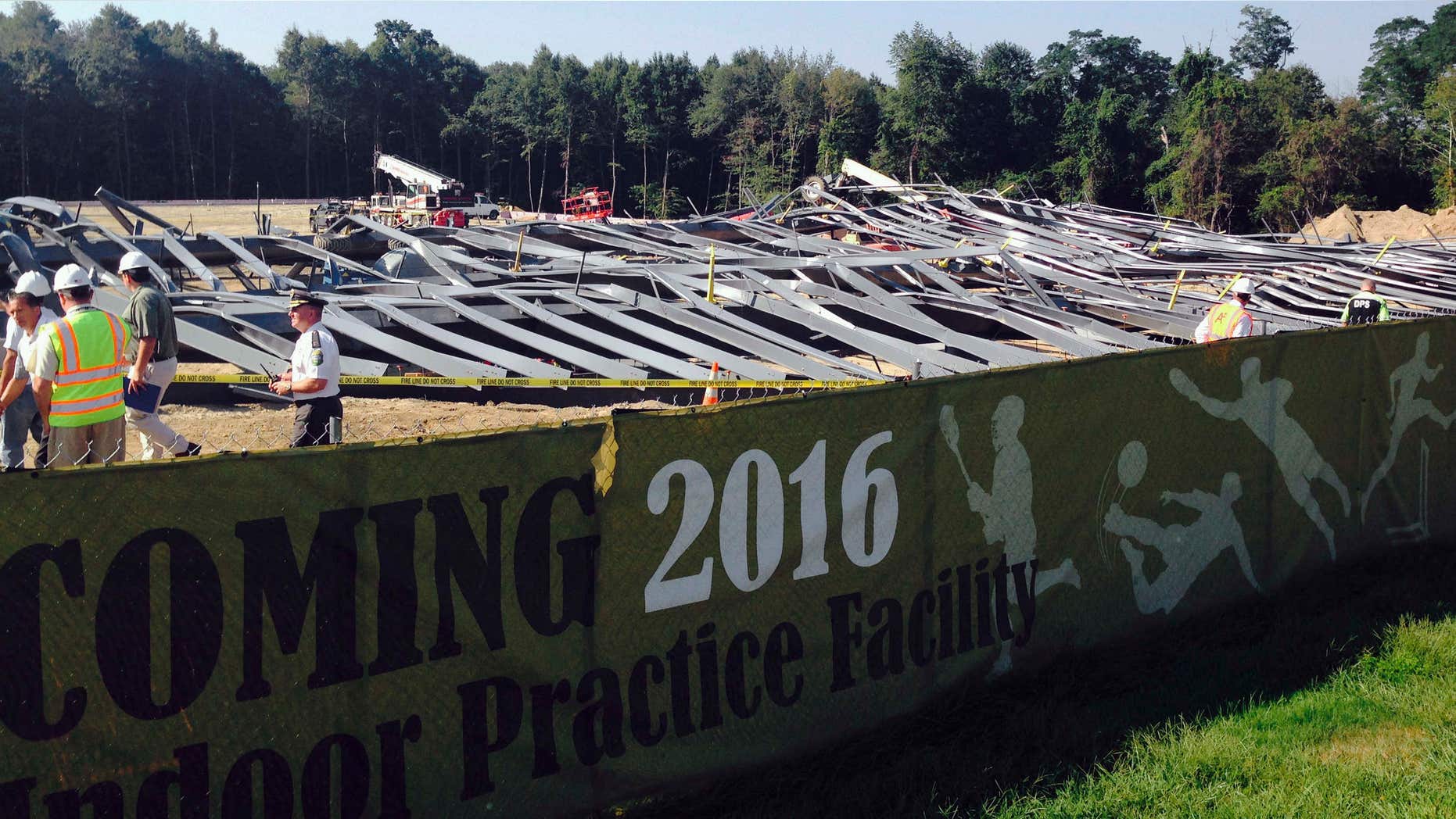 Sept. 1, 2015: People walk past bent steel at a construction site where an athletic practice facility on the Bryant University campus collapsed.
