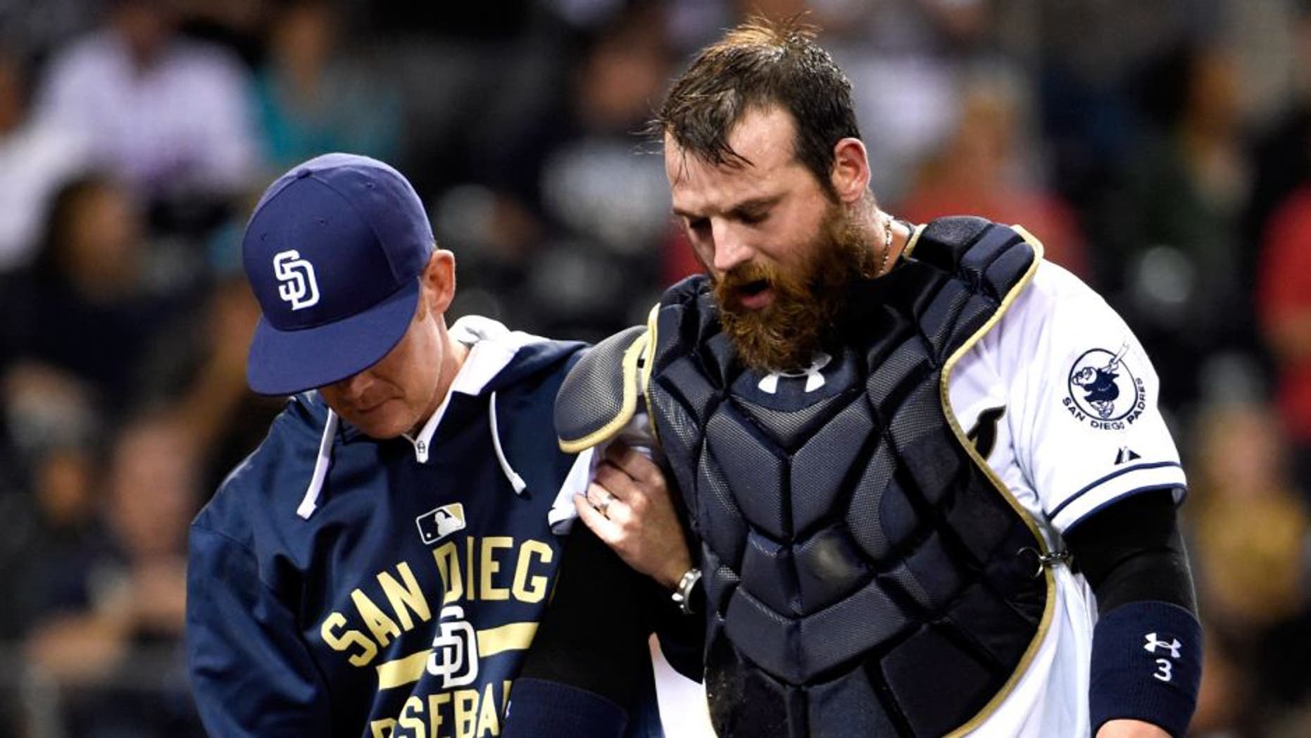 SAN DIEGO, CA - SEPTEMBER 1: Derek Norris #3 of the San Diego Padres, right, comes out of the game with a trainer during the seventh inning of a baseball game against the Texas Rangers at Petco Park September, 1, 2015 in San Diego, California. (Photo by Denis Poroy/Getty Images)
