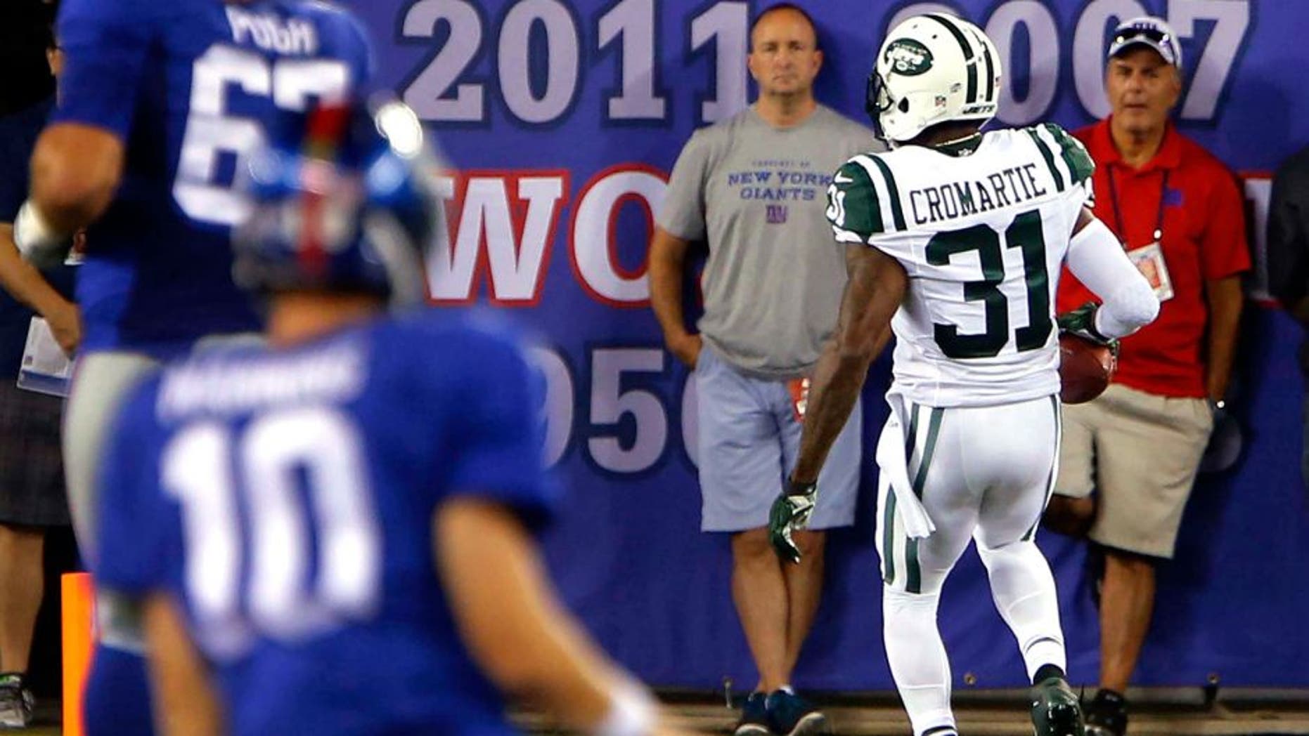 Aug 29, 2015; East Rutherford, NJ, USA; New York Giants quarterback Eli Manning (10) watches New York Jets defensive back Antonio Cromartie (31) score a touchdown after intercepting his pass during the first half at MetLife Stadium. Mandatory Credit: Noah K. Murray-USA TODAY Sports