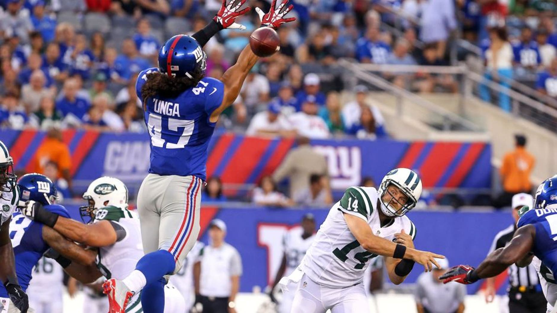 Aug 29, 2015; East Rutherford, NJ, USA; New York Jets quarterback Ryan Fitzpatrick (14) throws a pass while being defended by New York Giants linebacker Devin Unga (47) during the first half at MetLife Stadium. Mandatory Credit: Ed Mulholland-USA TODAY Sports