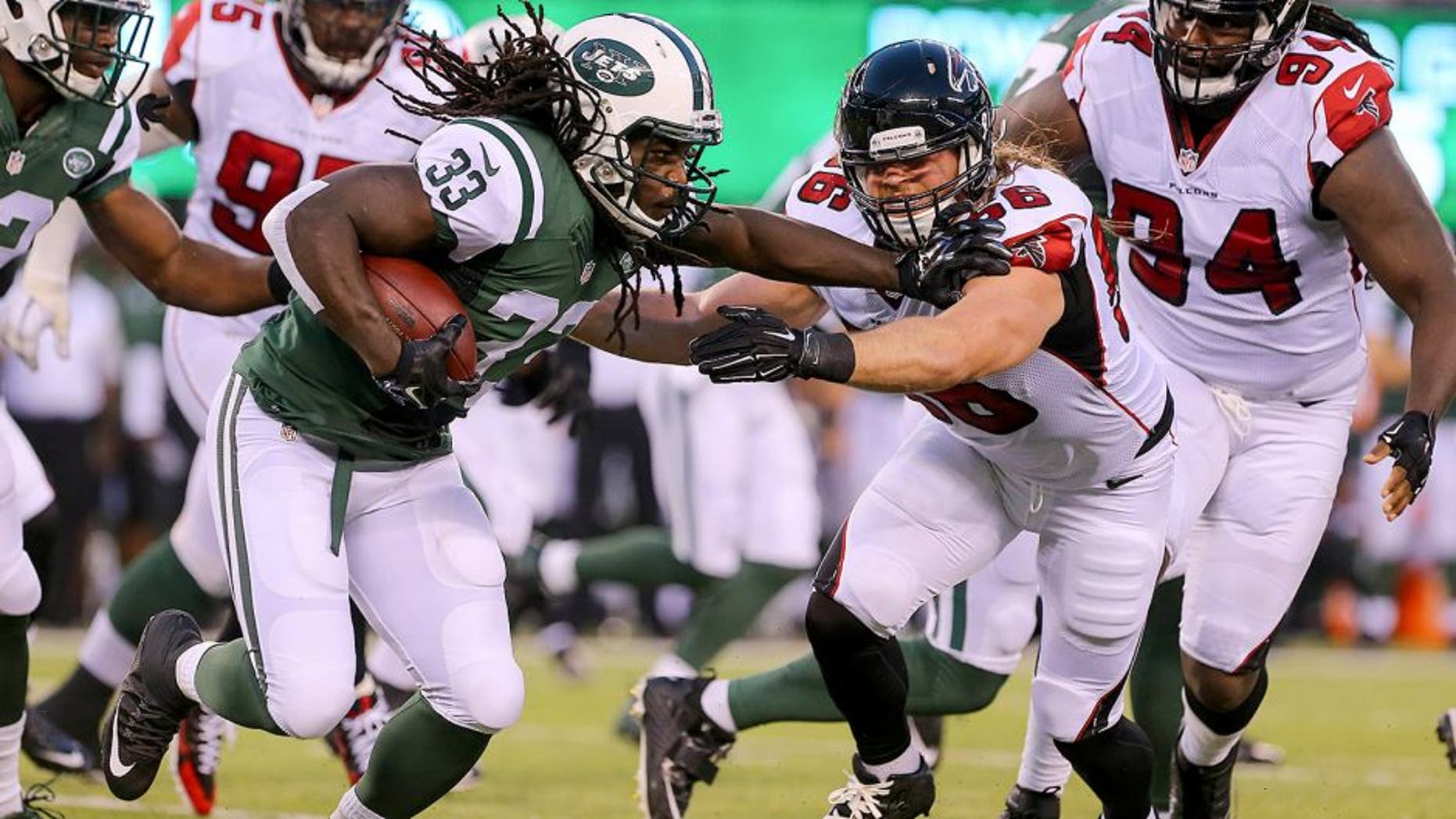 Aug 21, 2015; East Rutherford, NJ, USA; New York Jets running back Chris Ivory (33) runs with the ball while Atlanta Falcons linebacker Brooks Reed (56) attempts to tackle him during the first half at MetLife Stadium. Mandatory Credit: Ed Mulholland-USA TODAY Sports