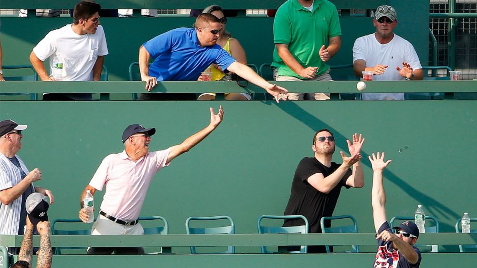 Fans in the Monster Seats go for a home run ball hit by New York Yankees' John Ryan Murphy during the second inning of a baseball game against the Boston Red Sox at Fenway Park in Boston Wednesday, Sept. 2, 2015. (AP Photo/Winslow Townson)
