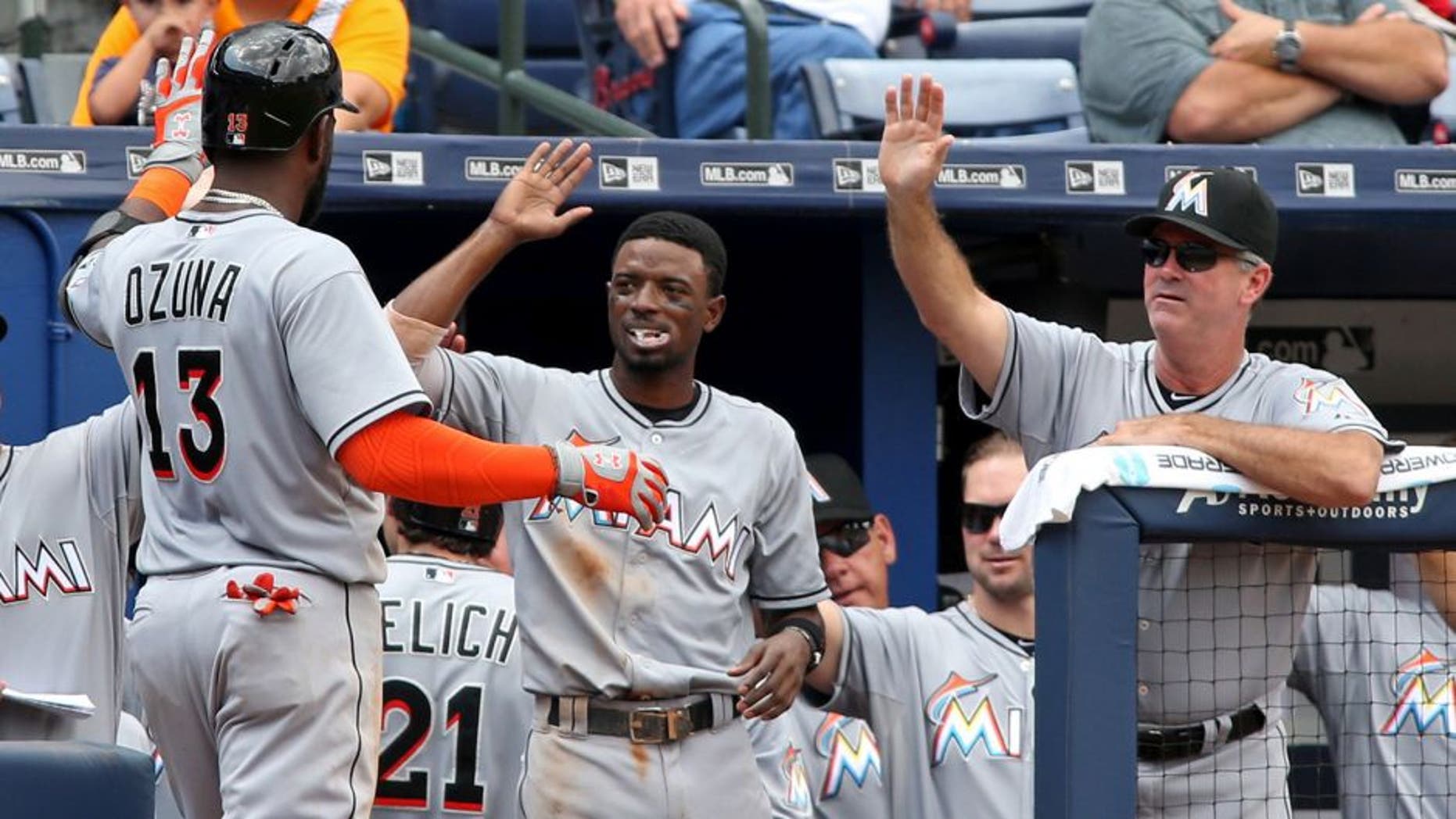 Sep 2, 2015; Atlanta, GA, USA; Miami Marlins center fielder Marcell Ozuna (13) celebrates his two-run home run with second baseman Dee Gordon (center) and manager Dan Jennings (26) in the fifth inning of their game against the Atlanta Braves at Turner Field. Mandatory Credit: Jason Getz-USA TODAY Sports