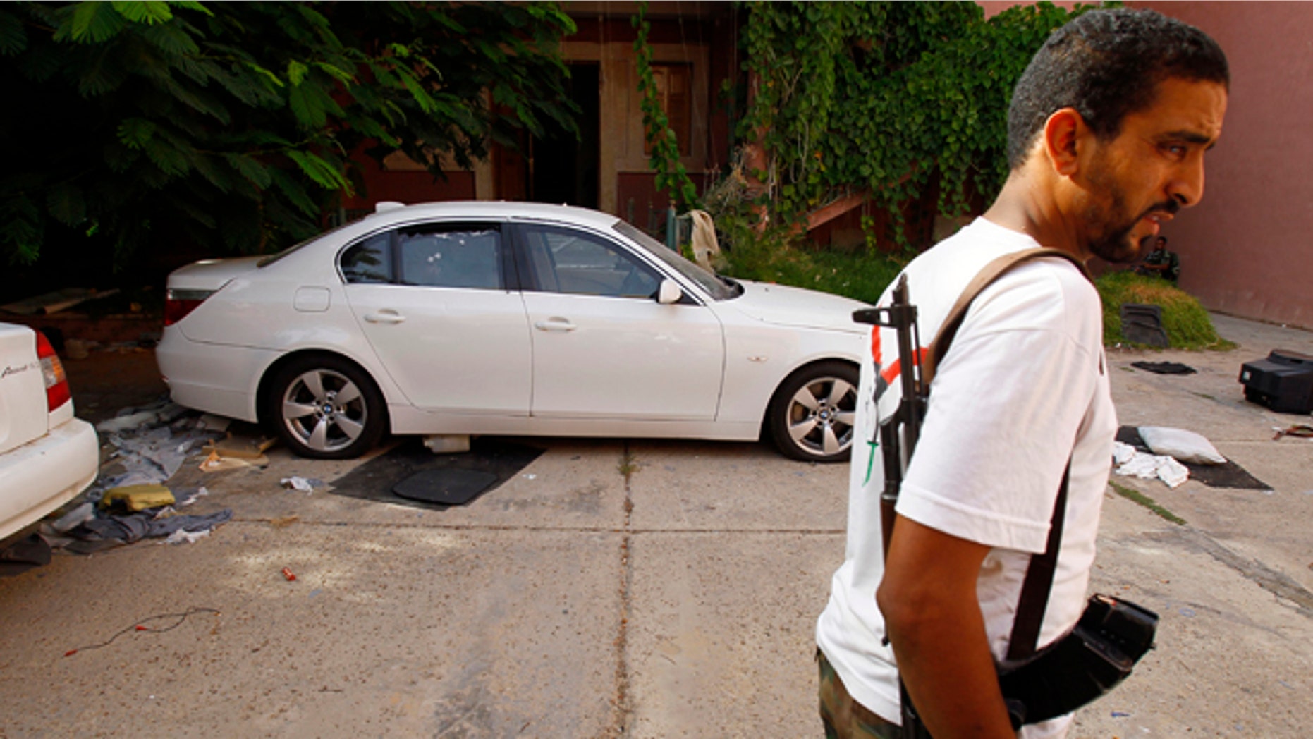 Sept. 1: Libyan rebel stands guards next to the armored car of of the ransacked office of Hannibal, son of Muammar Qaddafi at Bin Achour district inTripoli, Libya.