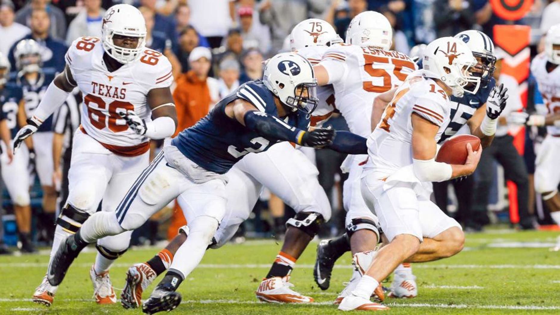 Sep 7, 2013; Provo, UT, USA; Texas Longhorns quarterback David Ash (14) tries to get away from Brigham Young Cougars linebacker Kyle Van Noy (3) during the first quarter at Lavell Edwards Stadium. Mandatory Credit: Chris Nicoll-USA TODAY Sports