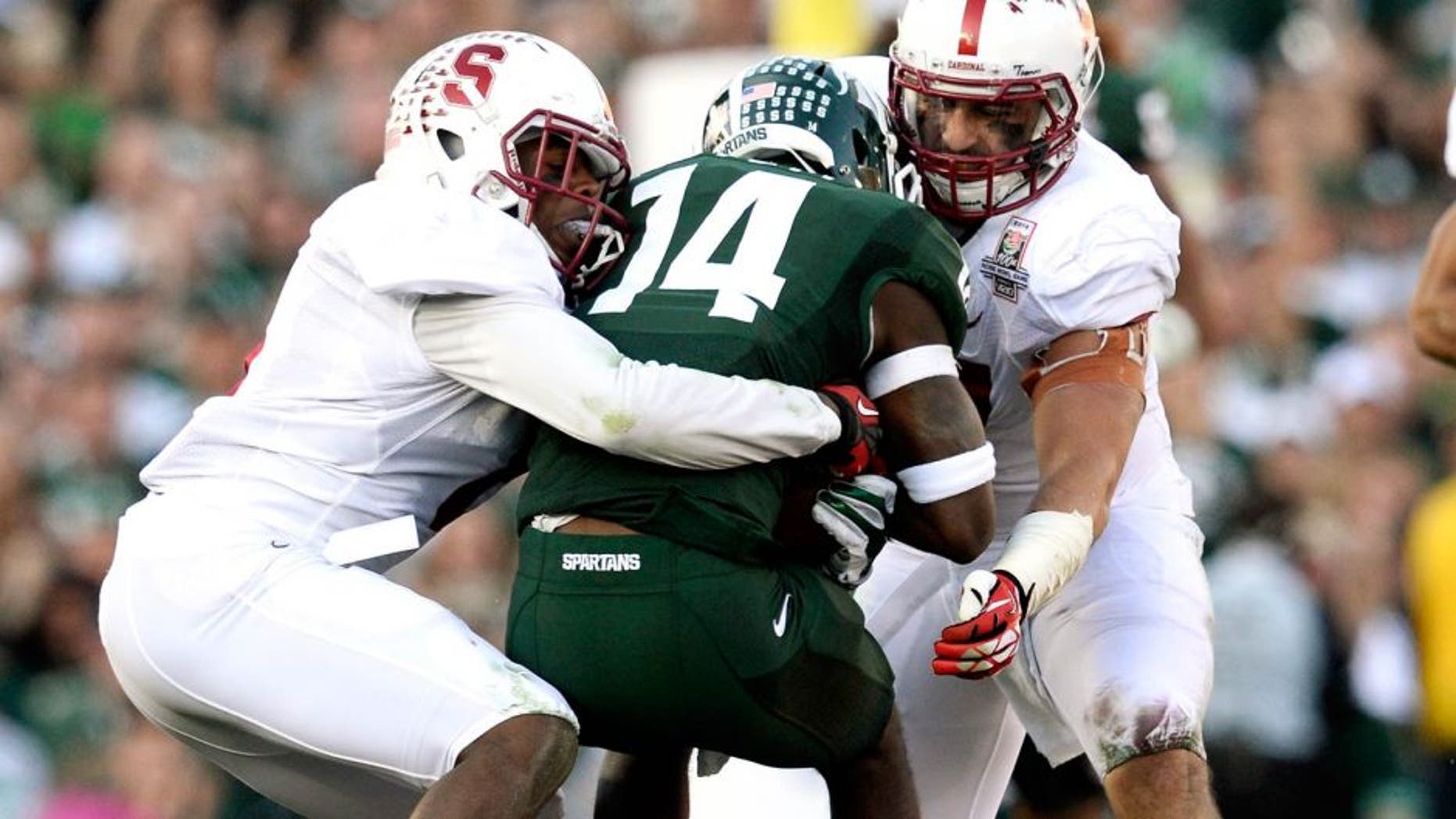 Jan 1, 2014; Pasadena, CA, USA; Stanford Cardinal safety Jordan Richards (8) and linebacker A.J. Tarpley (17) tackle Michigan State Spartans wide receiver Tony Lippett (14) during the first half at the Rose Bowl. Mandatory Credit: Robert Hanashiro-USA TODAY Sports