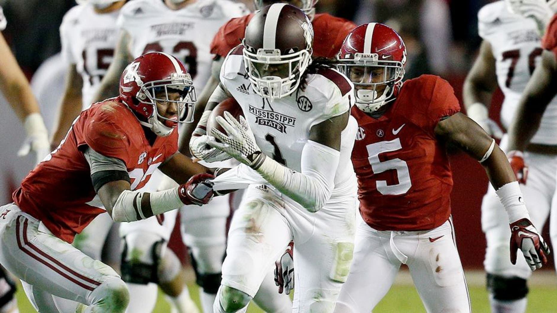 Nov 15, 2014; Tuscaloosa, AL, USA; Mississippi State Bulldogs wide receiver De'Runnya Wilson (1) is grabbed from behind by Alabama Crimson Tide defensive back Nick Perry (27) at Bryant-Denny Stadium. Mandatory Credit: Marvin Gentry-USA TODAY Sports