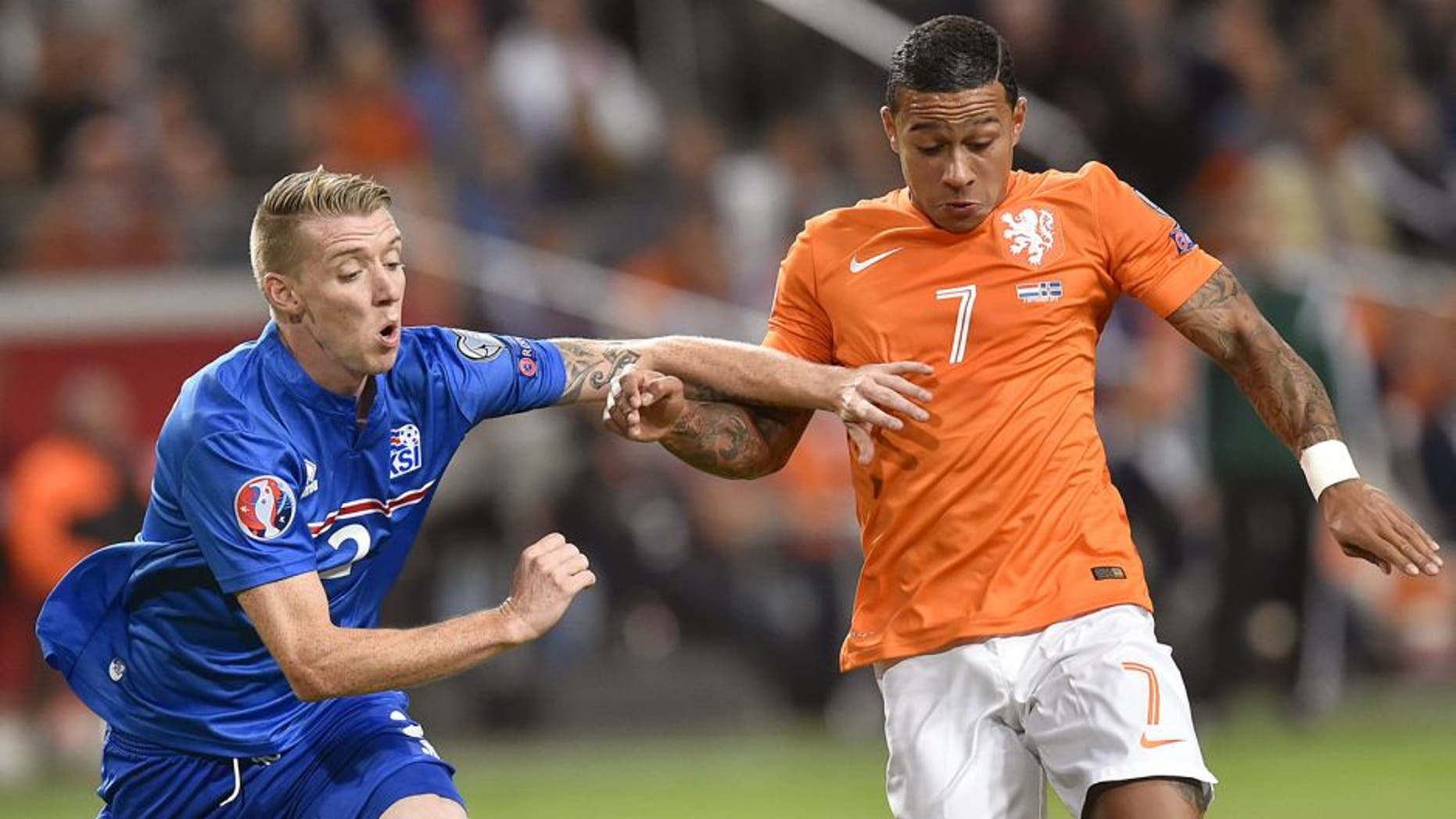 Iceland's defender Birkir Saevarsson (L) vies for the ball with Netherlands' Memphis Depay (R) during the UEFA Euro 2016 qualifying round football match between Netherlands and Iceland at the Arena Stadium, on September 3, 2015 in Amsterdam. AFP PHOTO / JOHN THYS (Photo credit should read JOHN THYS/AFP/Getty Images)