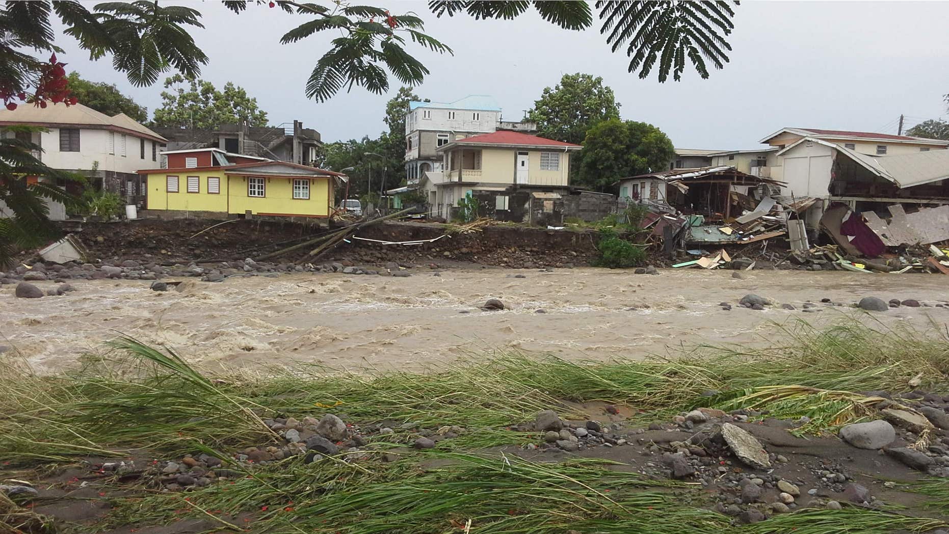 Aug. 27, 2015: A river overflows, affecting some homes along its banks, due to Tropical Storm Erika in Roseau, Dominica.
