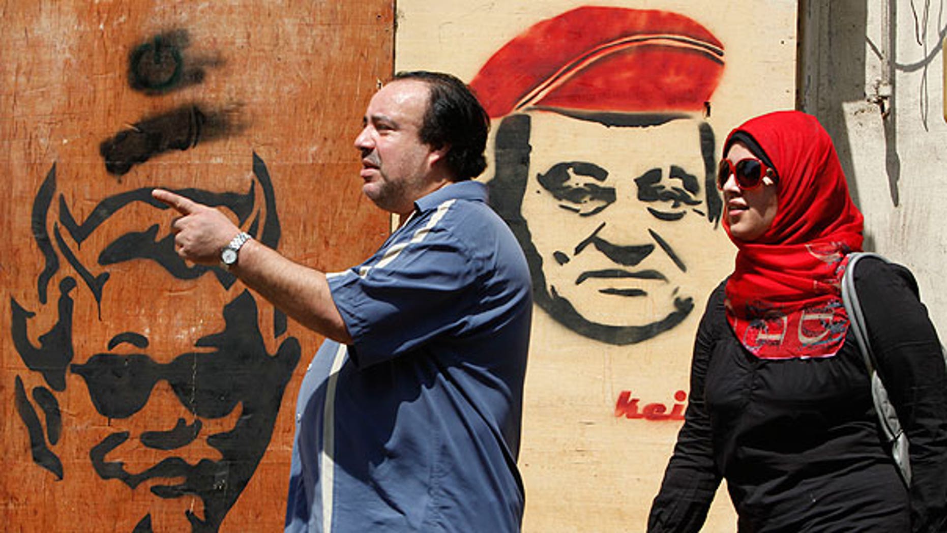 Sept. 4: Egyptians walk in front of an anti- ousted Egyptian President Hosni Mubarak graffiti in Cairo, Egypt, a day before the third trial session of him, his two sons, his former security chief and six other senior officials on charges of conspiring to kill protesters during mass uprising that ousted them from power.