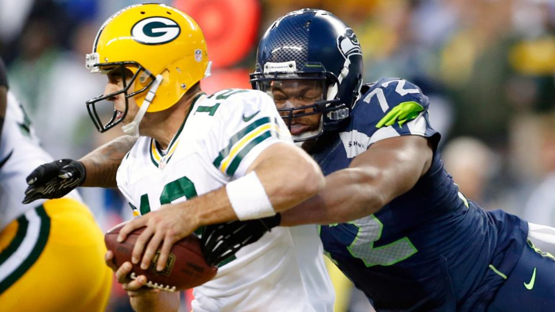 Sep 4, 2014; Seattle, WA, USA; Seattle Seahawks defensive end Michael Bennett (72) forces a fumble by Green Bay Packers quarterback Aaron Rodgers (12) during the third quarter at CenturyLink Field. The fumbles was recovered by Green Bay in the end zone for a safety. Mandatory Credit: Joe Nicholson-USA TODAY Sports