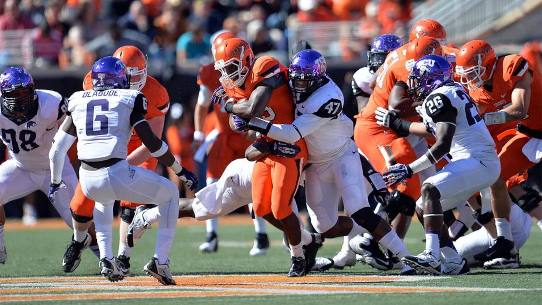Oct 19, 2013; Stillwater, OK, USA; Texas Christian Horned Frogs linebacker Paul Dawson (47) wraps up Oklahoma State Cowboys running back Rennie Childs (23) during the second half at Boone Pickens Stadium. Oklahoma State won 24-10. Mandatory Credit: Peter G. Aiken-USA TODAY Sports