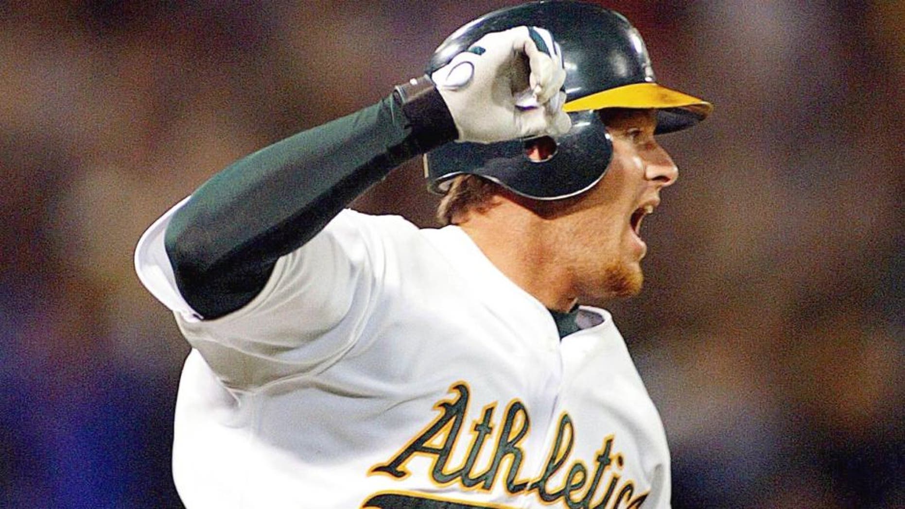 OAKLAND, UNITED STATES: Oakland Athletics' Scott Hatteberg raises his arms after hitting the game winning homerun against the Kansas City Royals 04 September 2002 during the bottom of the ninth inning off Royals' pitcher Jason Grimsley. It was the Athletics' 20th record straight win for the American League. The A's defeated the Royals 12-11. AFP PHOTO/John G. MABANGLO (Photo credit should read JOHN G. MABANGLO/AFP/Getty Images)