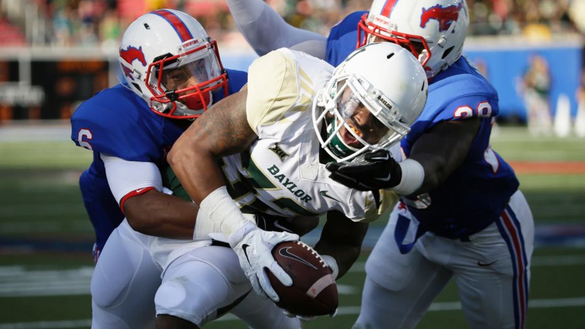 Baylor running back Shock Linwood (32) runs against SMU defenders Shakiel Randolph, right, and Jesse Montgomery (6) during the first half of an NCAA college football game Friday, Sept. 4, 2015, in Dallas. (AP Photo/LM Otero)