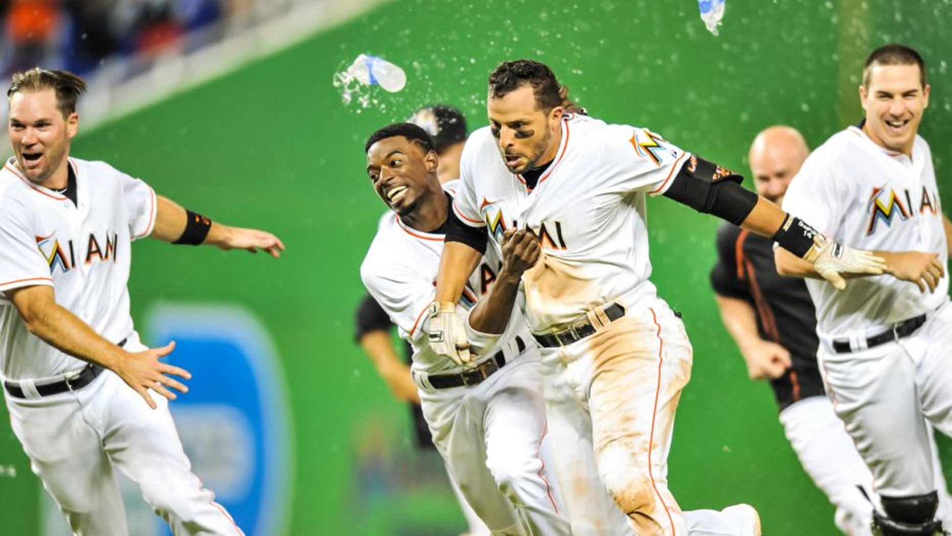 Sep 4, 2015; Miami, FL, USA; Miami Marlins third baseman Martin Prado (14) celebrates with Miami Marlins second baseman Dee Gordon (left) after Prado hit the game winning RBI single to defeat the New York Mets 6-5 in 11 inning at Marlins Park. Mandatory Credit: Steve Mitchell-USA TODAY Sports