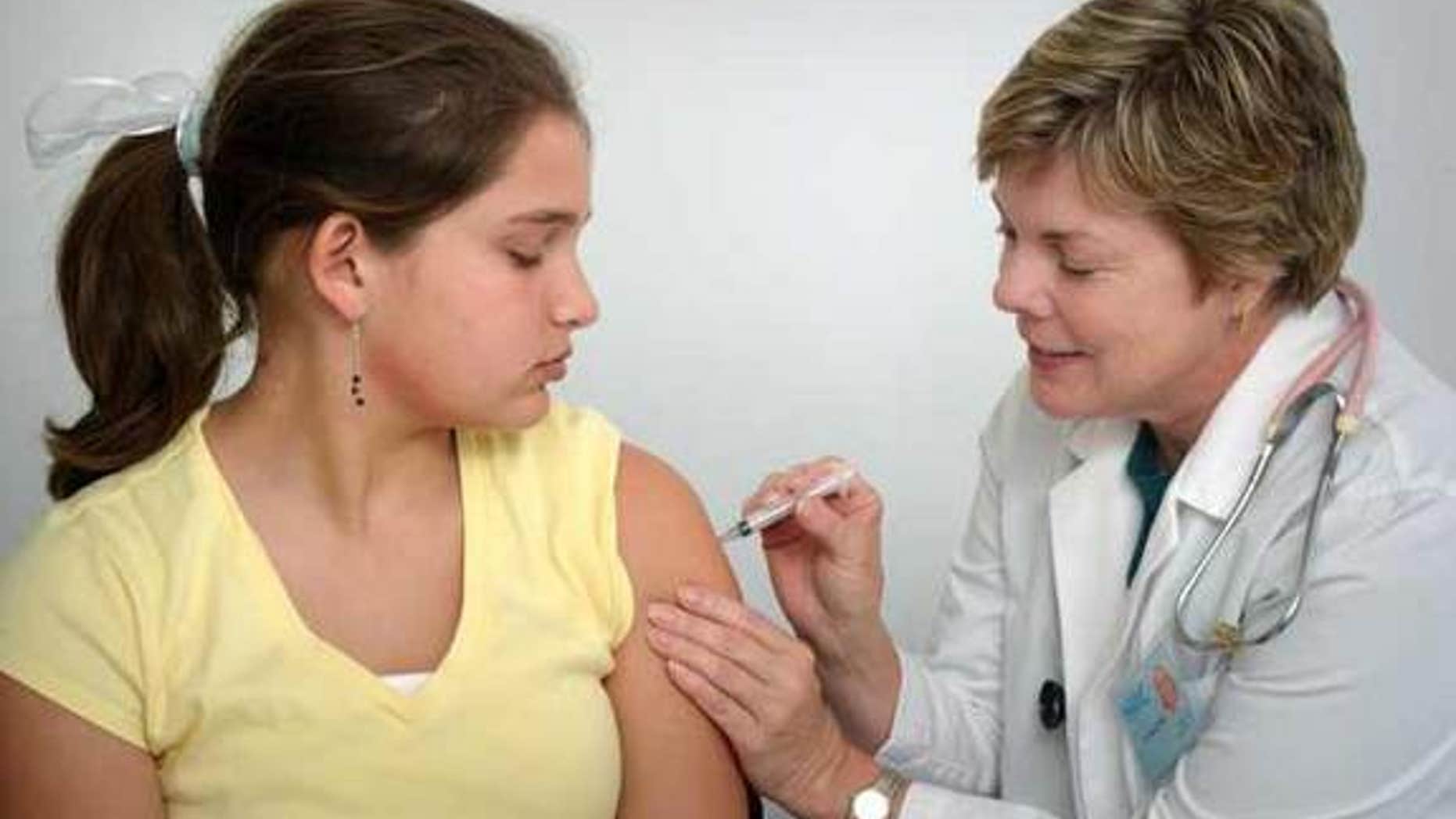 The nurse in this 2006 photograph was in the process of administering an intramuscular vaccination in the left shoulder muscle of a young girl. The nurse was pinching the overlying shoulder skin, in order to immobilize the injection site.