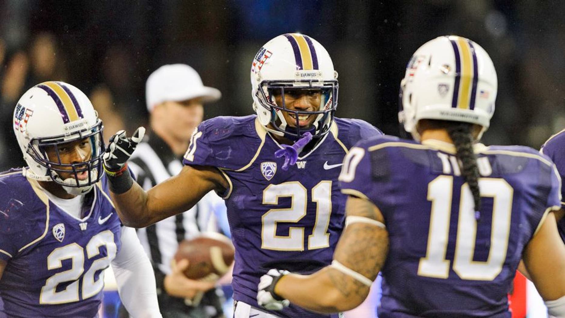 Nov 9, 2013; Seattle, WA, USA; Washington Huskies defensive back Marcus Peters (21) celebrates with defensive end Josh Shirley (22) and linebacker John Timu (10) after Peters intercepted the ball and ran it back for a touchdown against the Colorado Buffaloes during the 2nd half at Husky Stadium. Washington defeated Colorado 59-7. Mandatory Credit: Steven Bisig-USA TODAY Sports